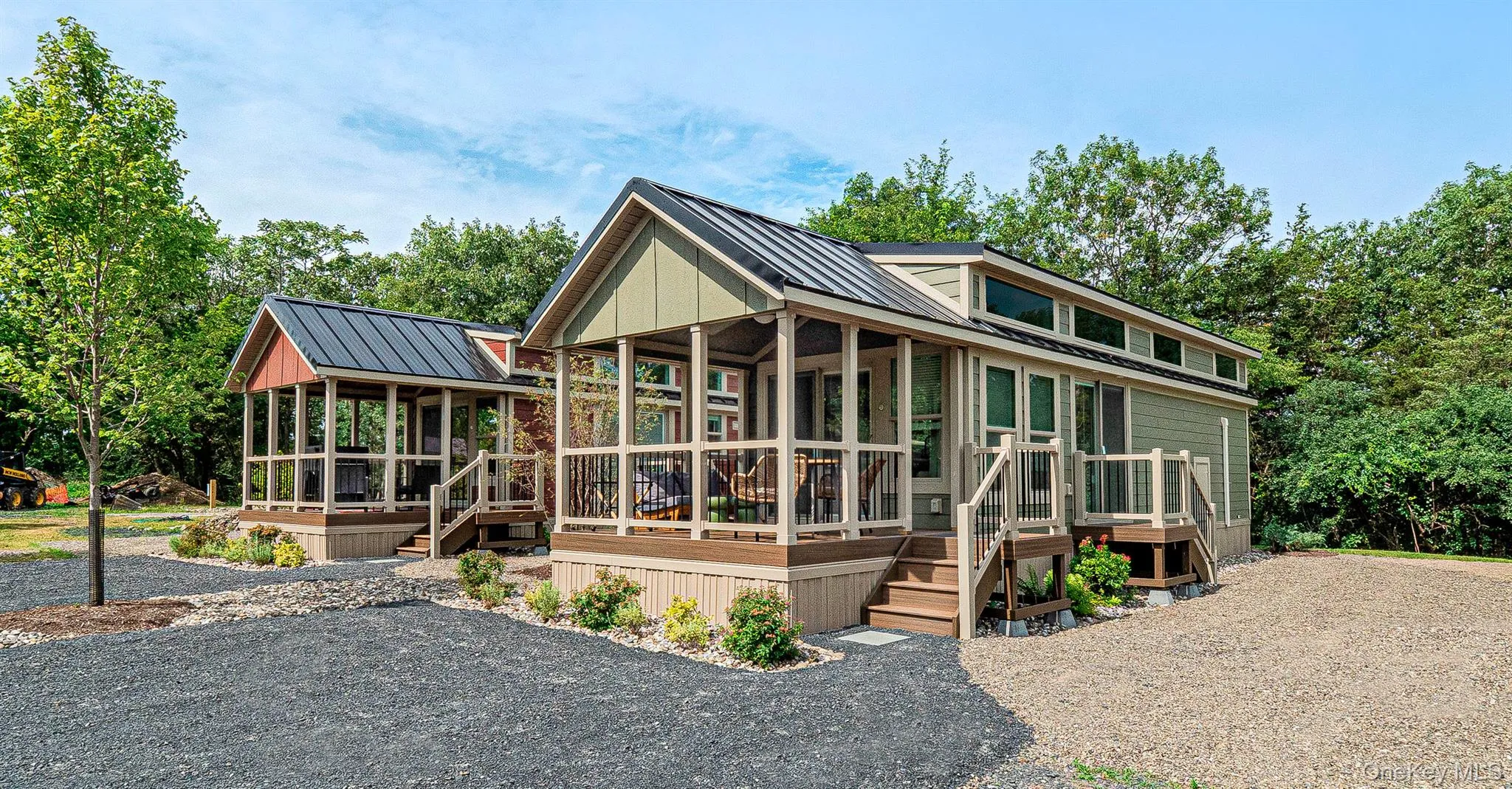 View of front of property featuring a standing seam roof, a metal roof, and a wooden deck View of front of property featuring a standing seam roof, a metal roof, and a wooden deck