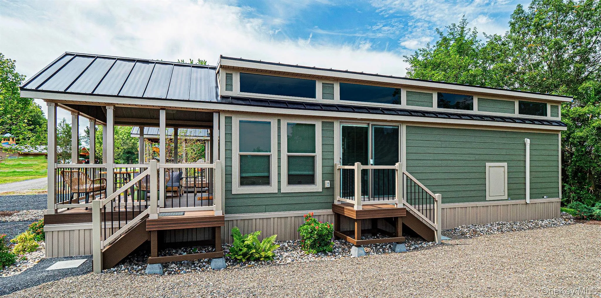 View of side with a metal roof, a porch, and a wooden deck View of side with a metal roof, a porch, and a wooden deck