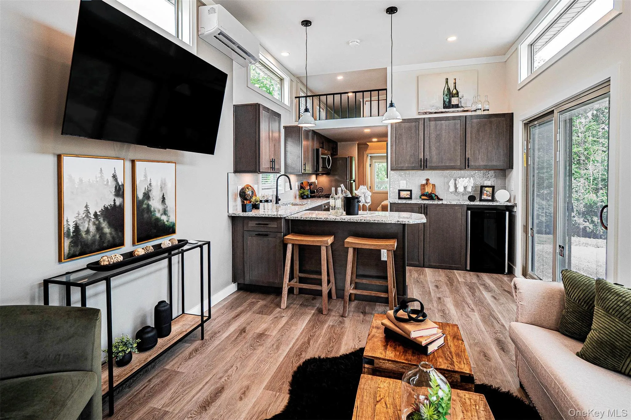 Kitchen featuring dark brown cabinets, light stone counters, a peninsula, light wood-style flooring, and recessed lighting Kitchen featuring dark brown cabinets, light stone counters, a peninsula, light wood-style flooring, and recessed lighting