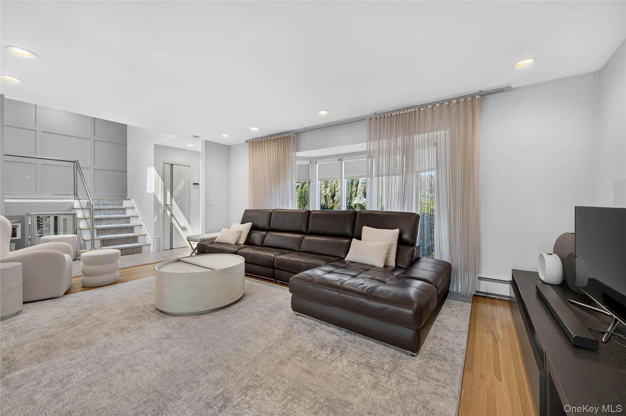 Open-concept living area featuring light wood-finish flooring and recessed lighting Open-concept living area featuring light wood-finish flooring and recessed lighting