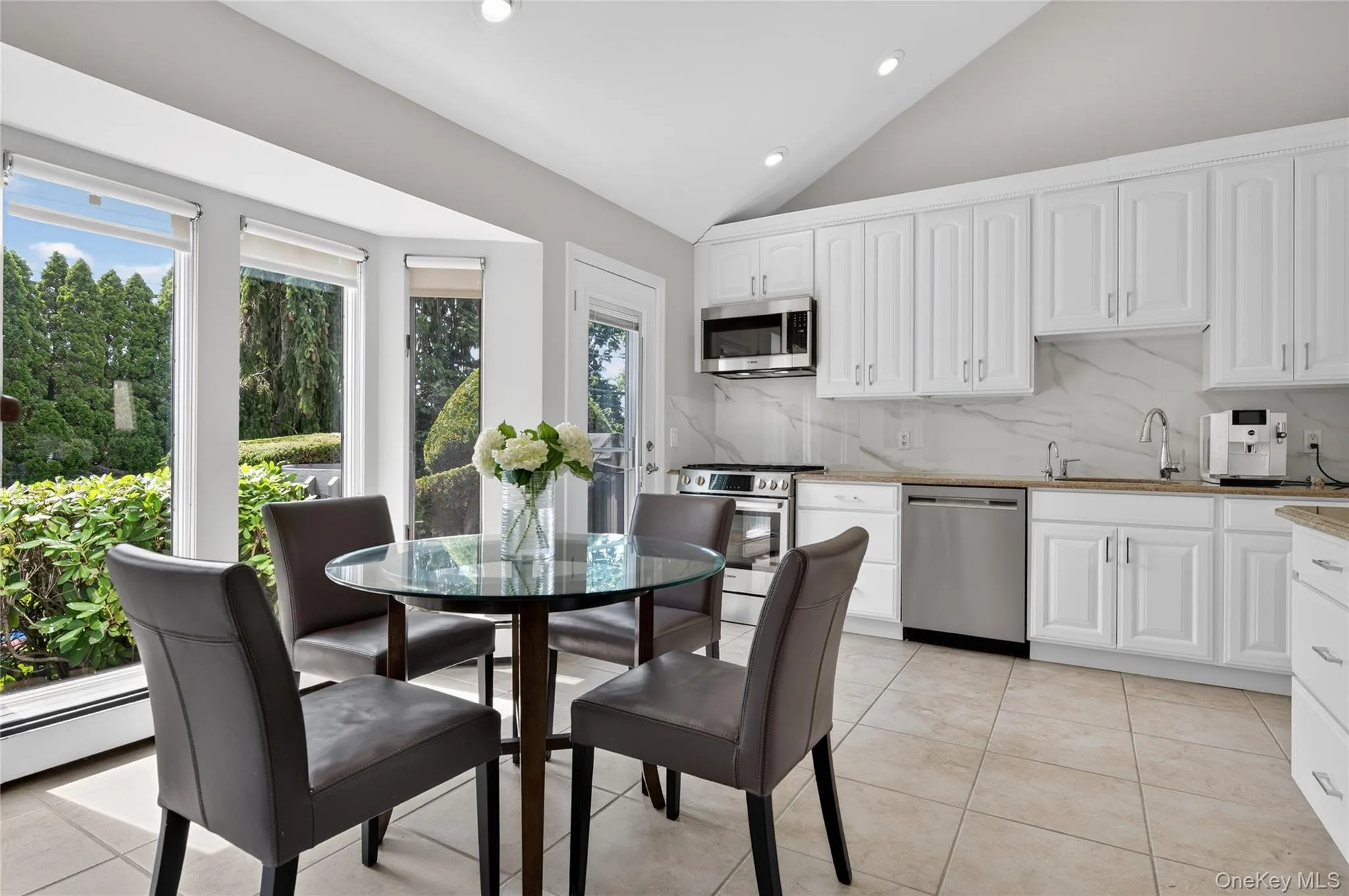 Kitchen featuring GAS stove, white cabinetry, stainless steel appliances, natural granite countertops, and tile flooring Kitchen featuring GAS stove, white cabinetry, stainless steel appliances, natural granite countertops, and tile flooring