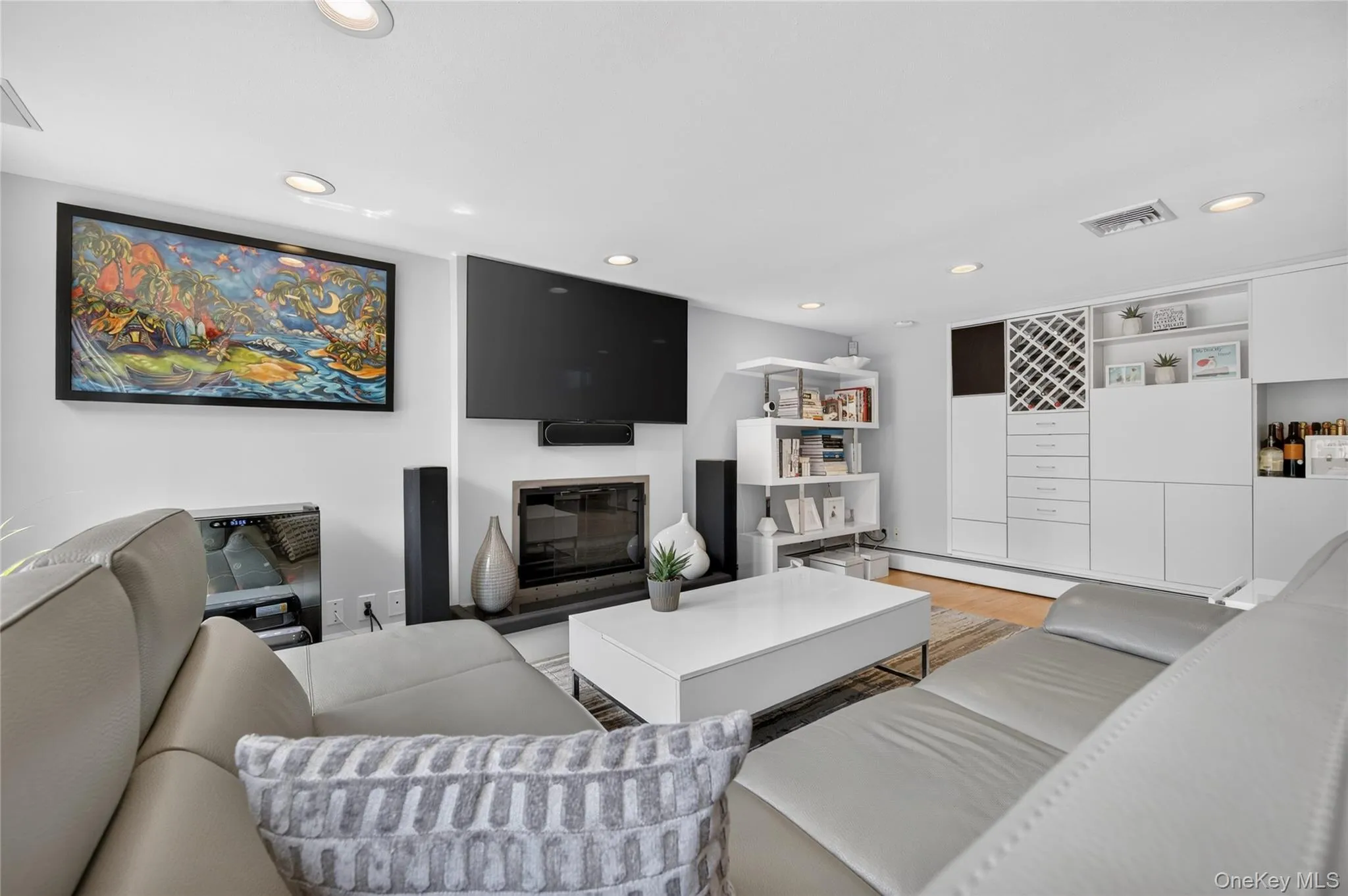 Living area featuring a fireplace with built-in white cabinetry with a wine rack Living area featuring a fireplace with built-in white cabinetry with a wine rack