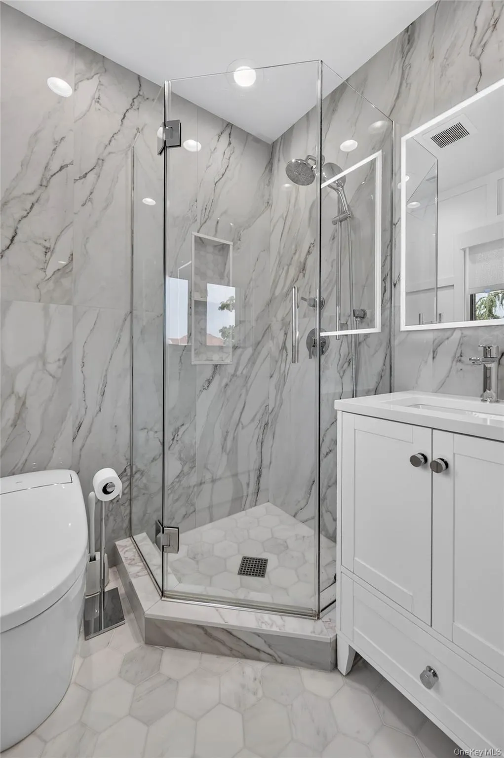 Renovated primary bathroom with glass-enclosed shower and built-in niche Renovated primary bathroom with glass-enclosed shower and built-in niche