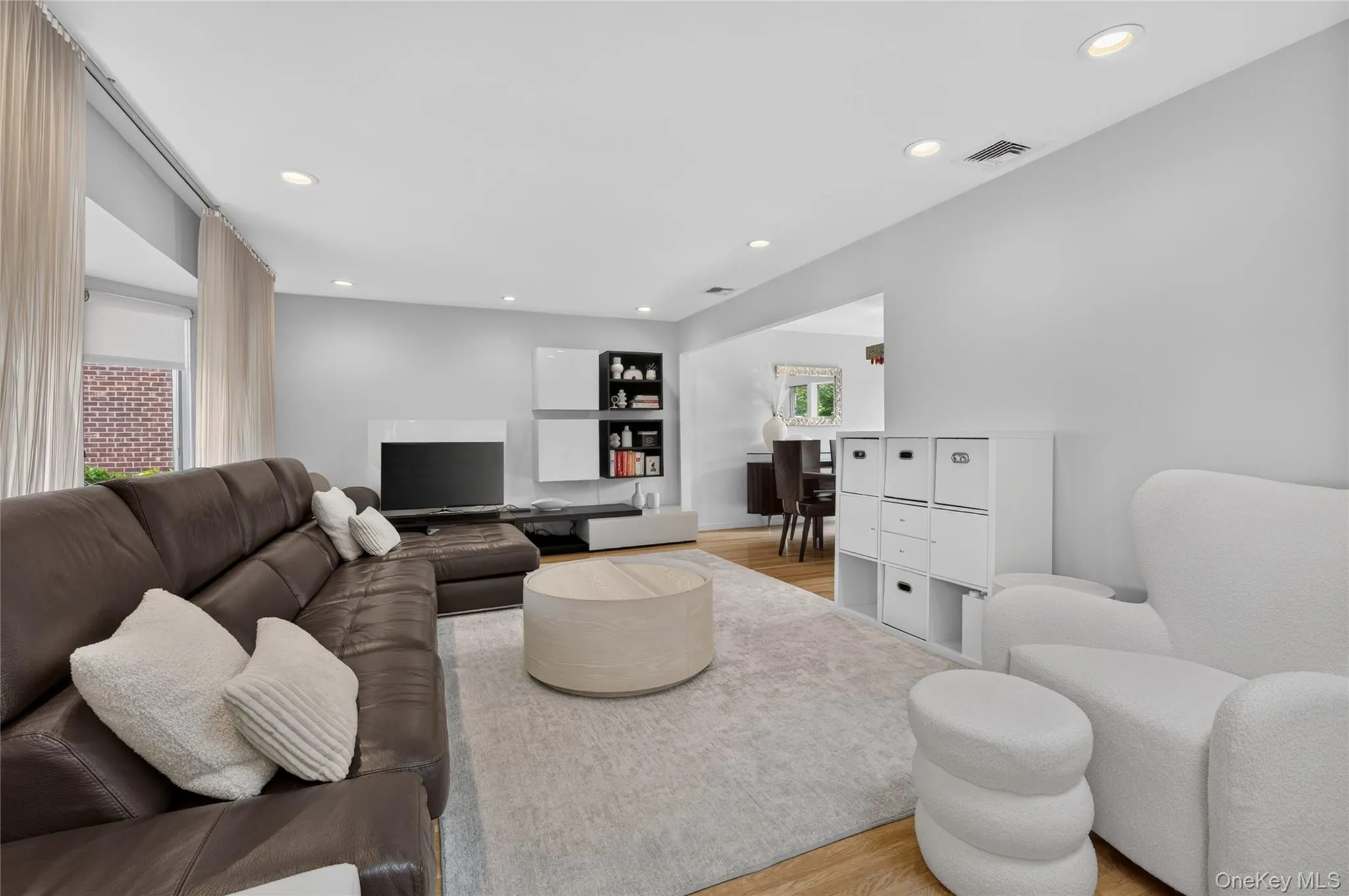 Open-concept living area featuring recessed lighting, light wood-finish flooring, and a large bay window Open-concept living area featuring recessed lighting, light wood-finish flooring, and a large bay window