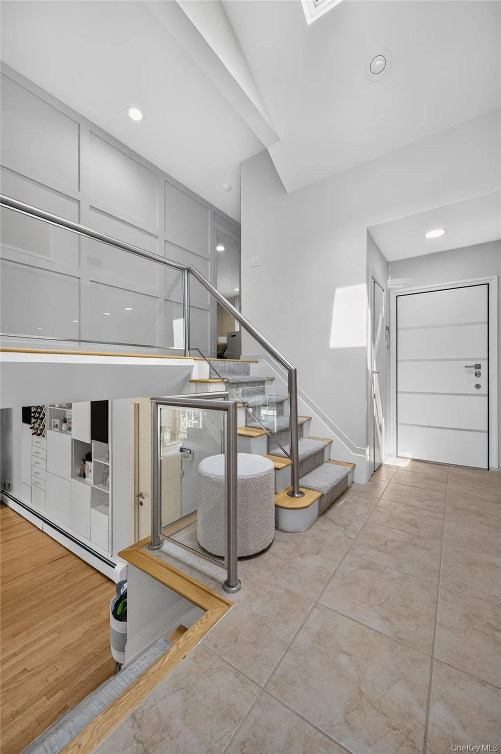 View of European front door, staircase, glass-panel railings and accent wall View of European front door, staircase, glass-panel railings and accent wall