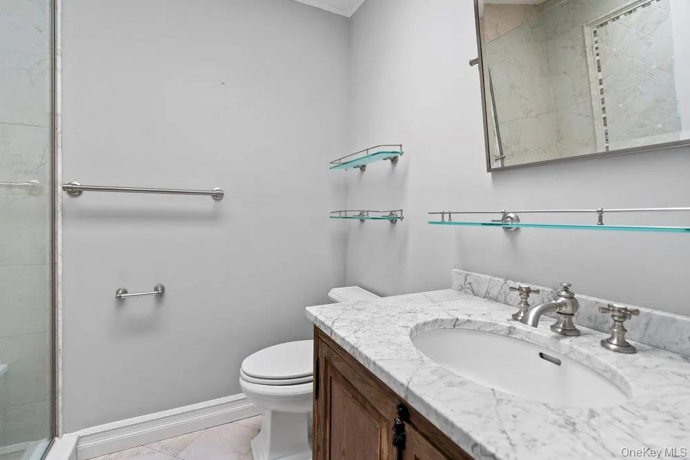 Bathroom vanity with a white oval sink, marble countertop, and brushed nickel fixtures Bathroom vanity with a white oval sink, marble countertop, and brushed nickel fixtures