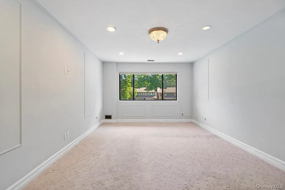 Spacious room featuring a large window, recessed lighting, and crown molding will have wood floors Spacious room featuring a large window, recessed lighting, and crown molding will have wood floors