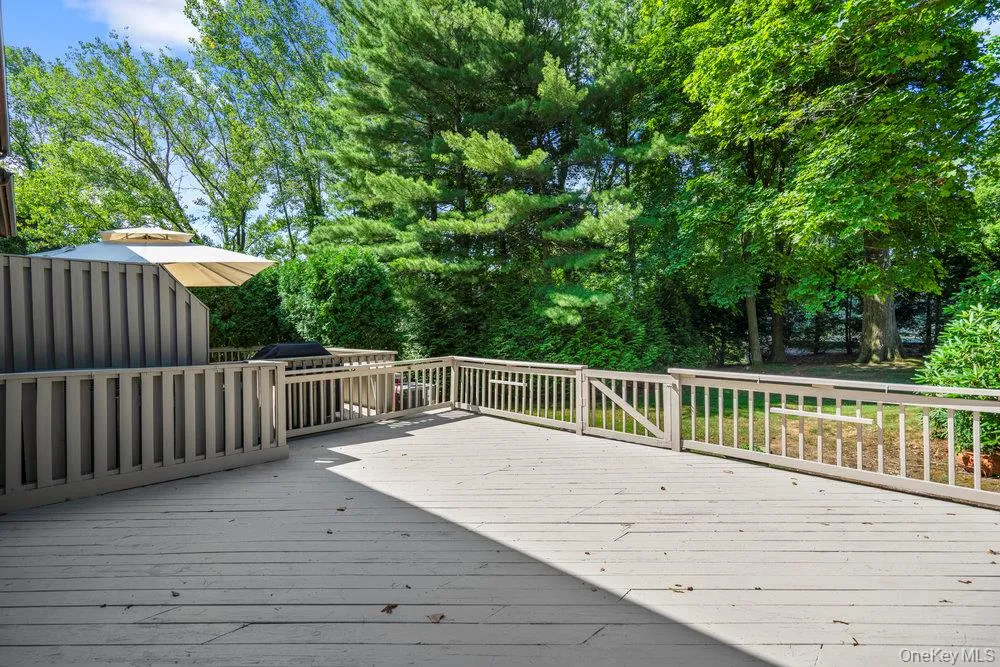 Expansive outdoor deck featuring wood-finish flooring and a full perimeter railing Expansive outdoor deck featuring wood-finish flooring and a full perimeter railing