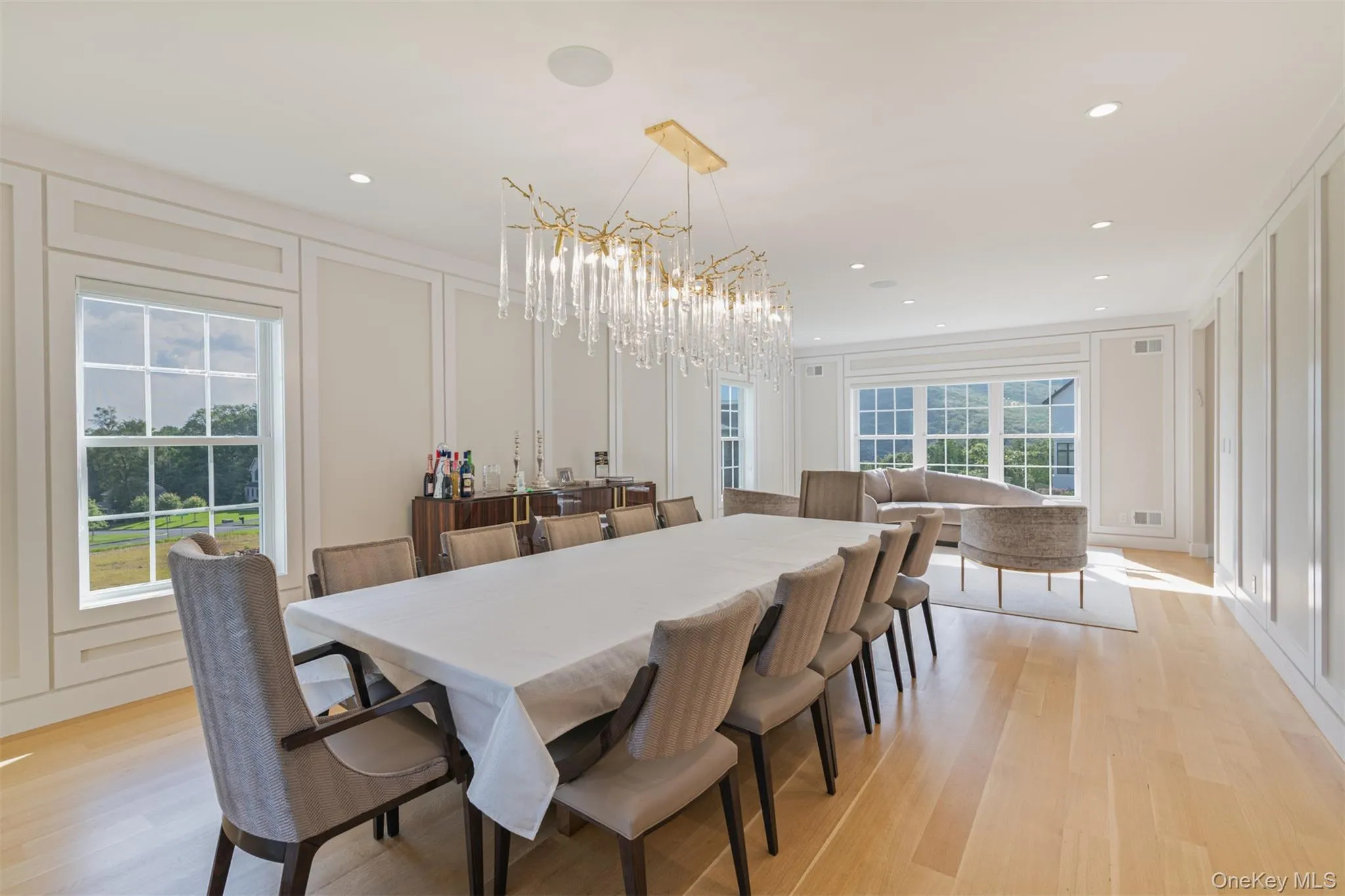 Dining space featuring a decorative wall, light wood-type flooring, recessed lighting, and a chandelier Dining space featuring a decorative wall, light wood-type flooring, recessed lighting, and a chandelier