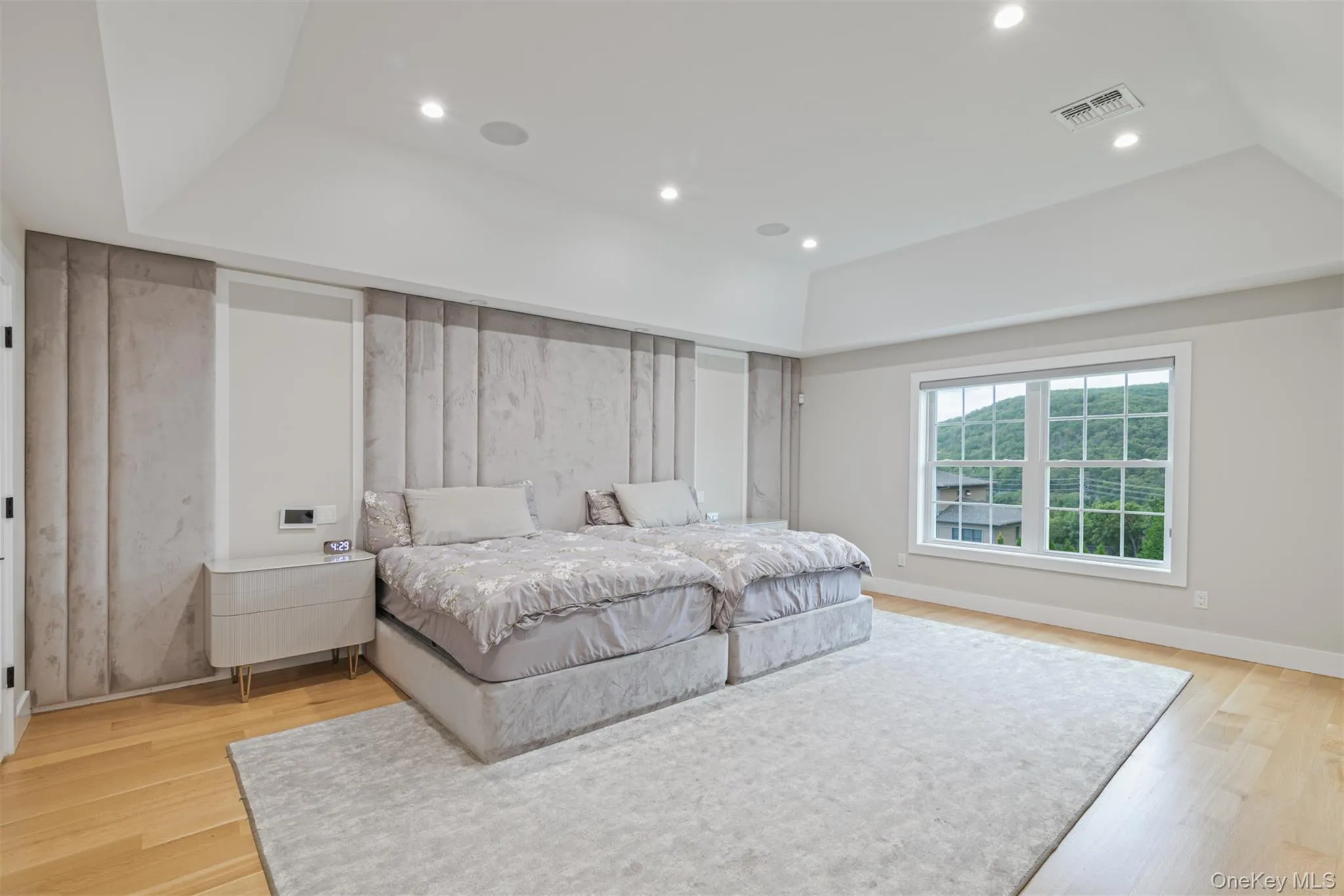 Bedroom featuring a raised ceiling, light wood finished floors, and recessed lighting Bedroom featuring a raised ceiling, light wood finished floors, and recessed lighting