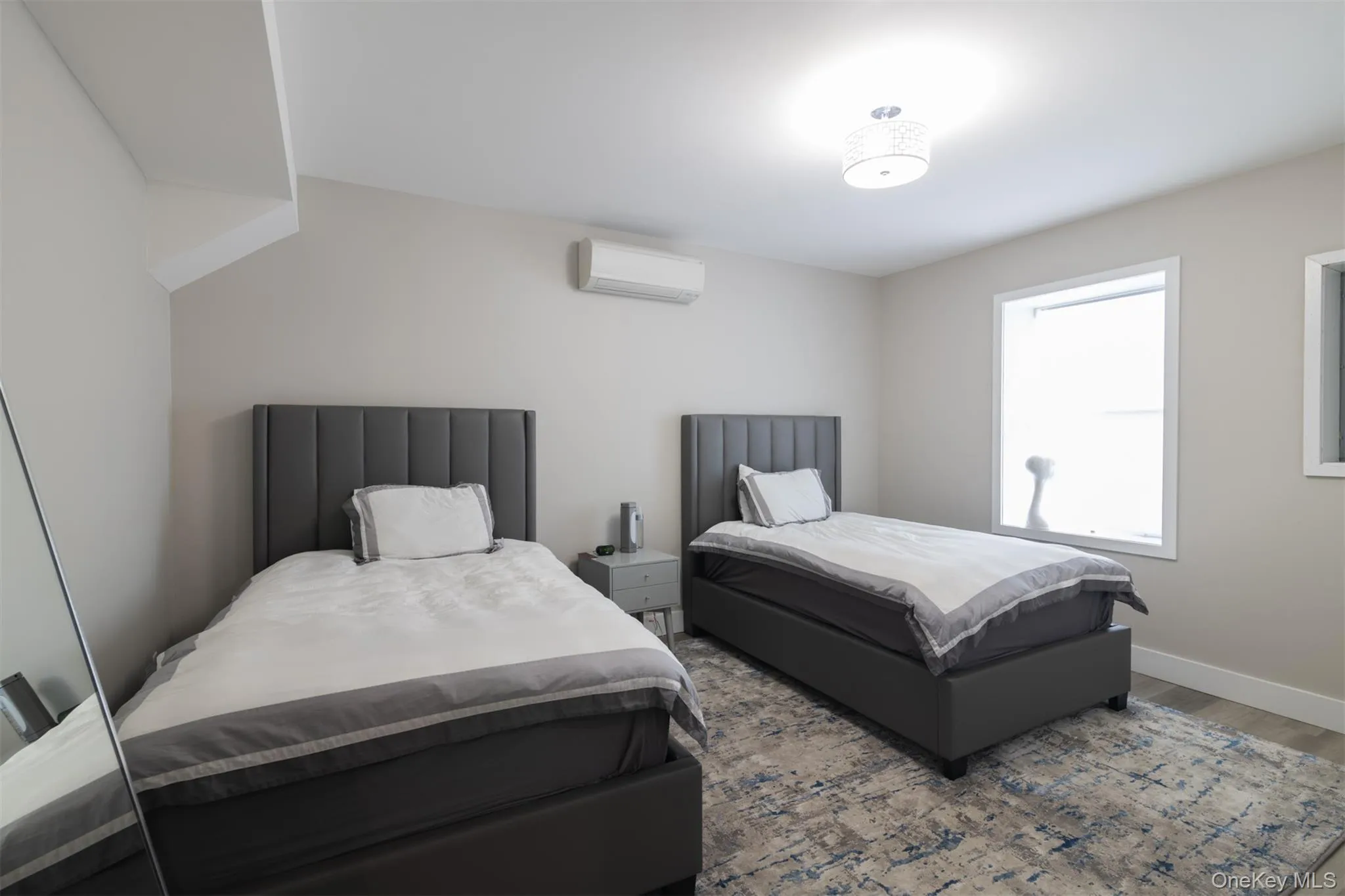 Bedroom with wood finished floors and a wall unit AC Bedroom with wood finished floors and a wall unit AC