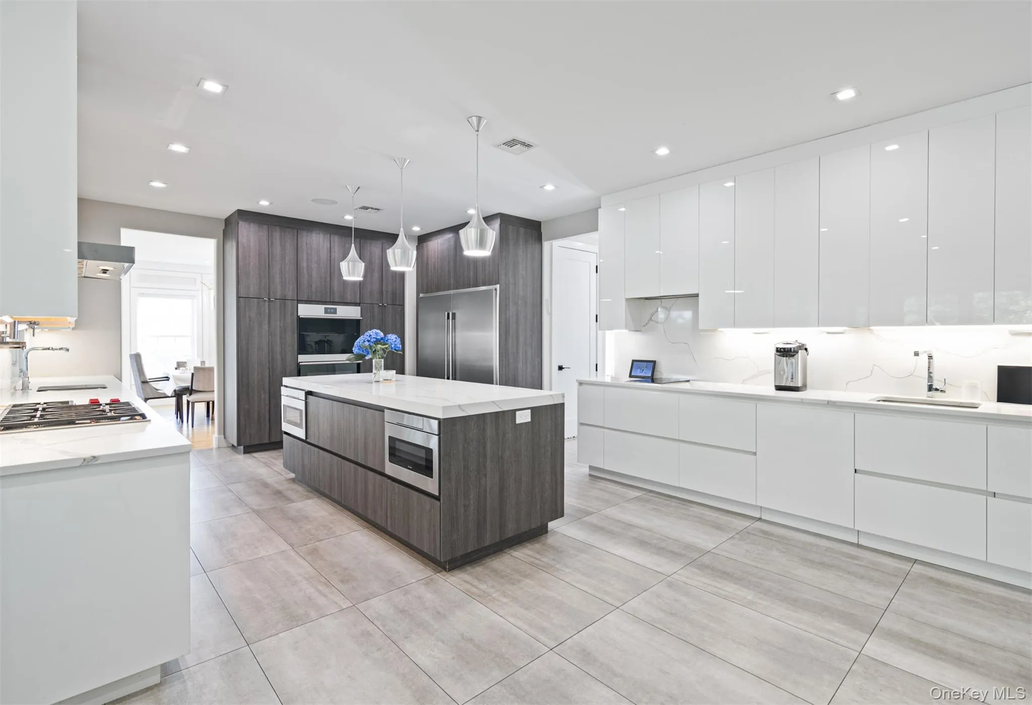 Kitchen featuring modern cabinets, white cabinetry, light stone counters, stainless steel appliances, and recessed lighting Kitchen featuring modern cabinets, white cabinetry, light stone counters, stainless steel appliances, and recessed lighting