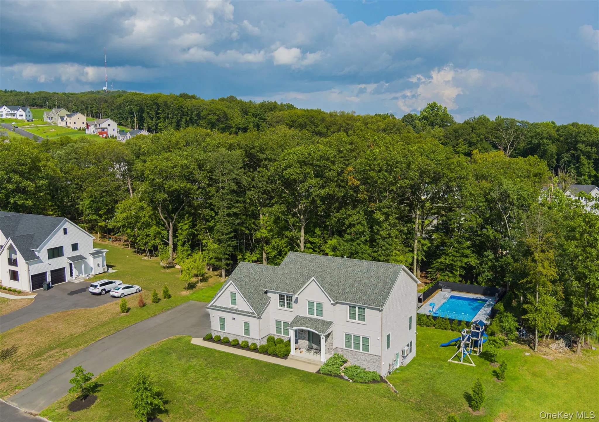 Aerial view of property and surrounding area featuring a heavily wooded area and a pool area Aerial view of property and surrounding area featuring a heavily wooded area and a pool area