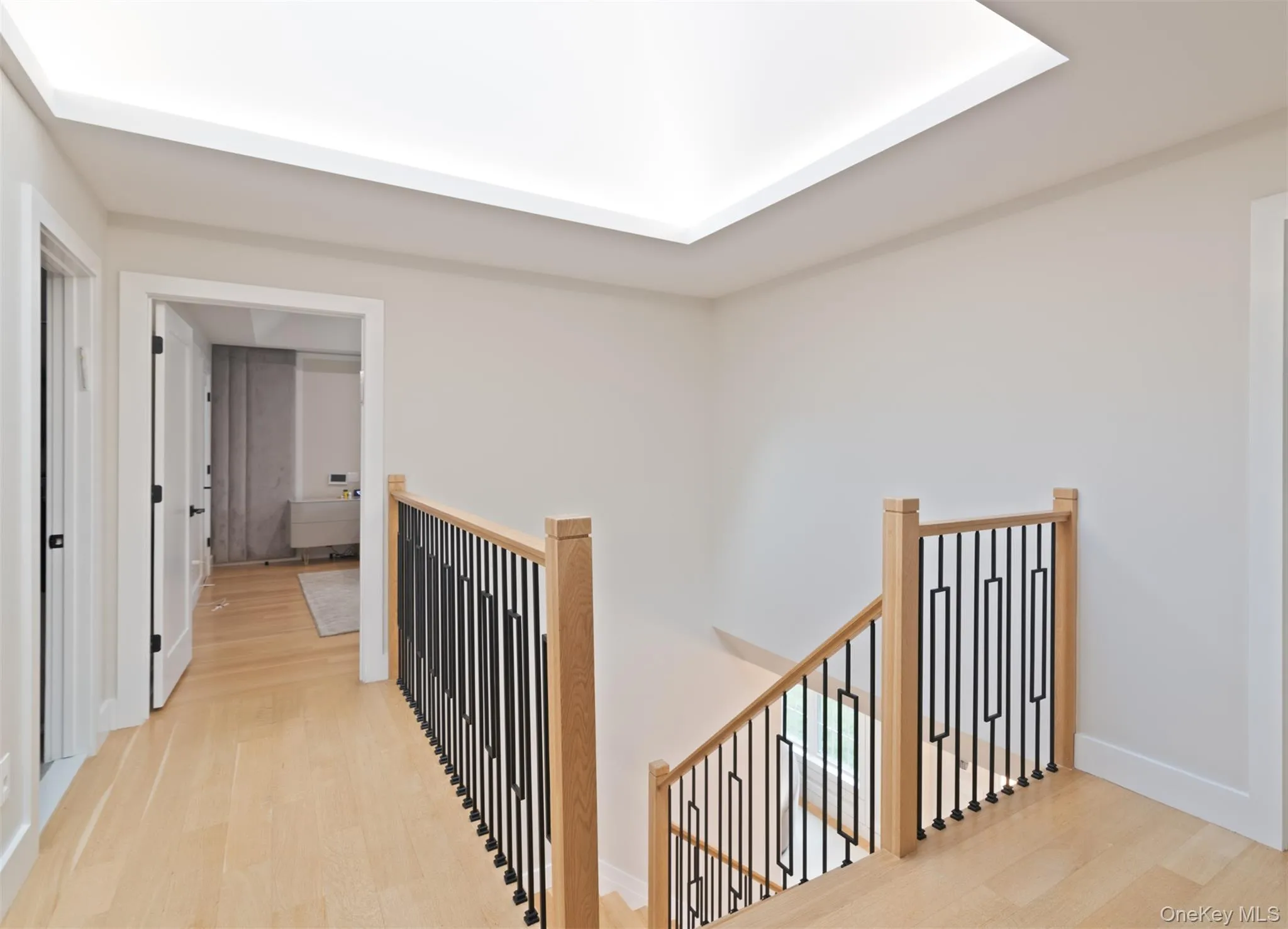 Hallway with light wood finished floors and an upstairs landing Hallway with light wood finished floors and an upstairs landing