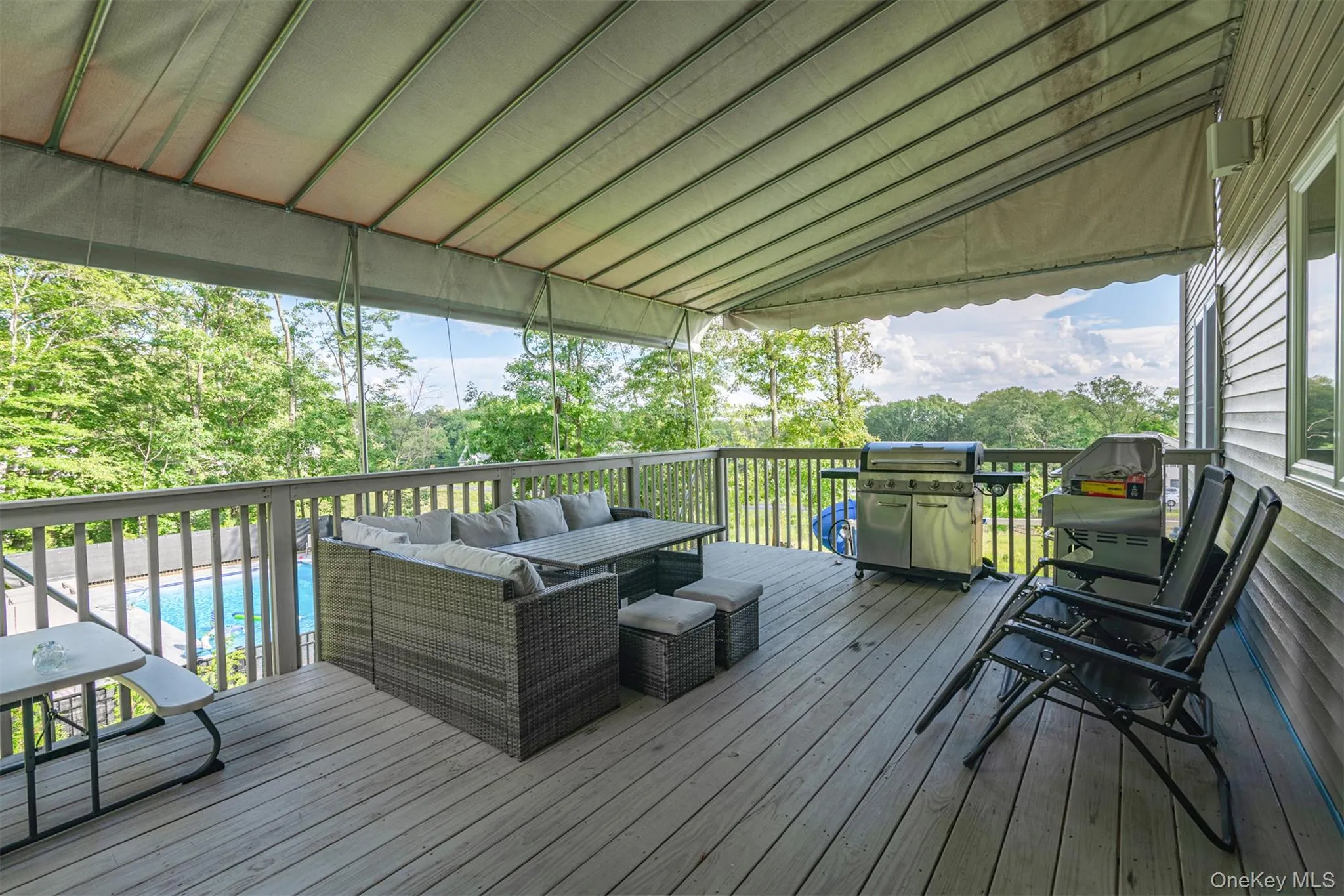 Wooden deck featuring an outdoor hangout area, grilling area, and view of wooded area Wooden deck featuring an outdoor hangout area, grilling area, and view of wooded area