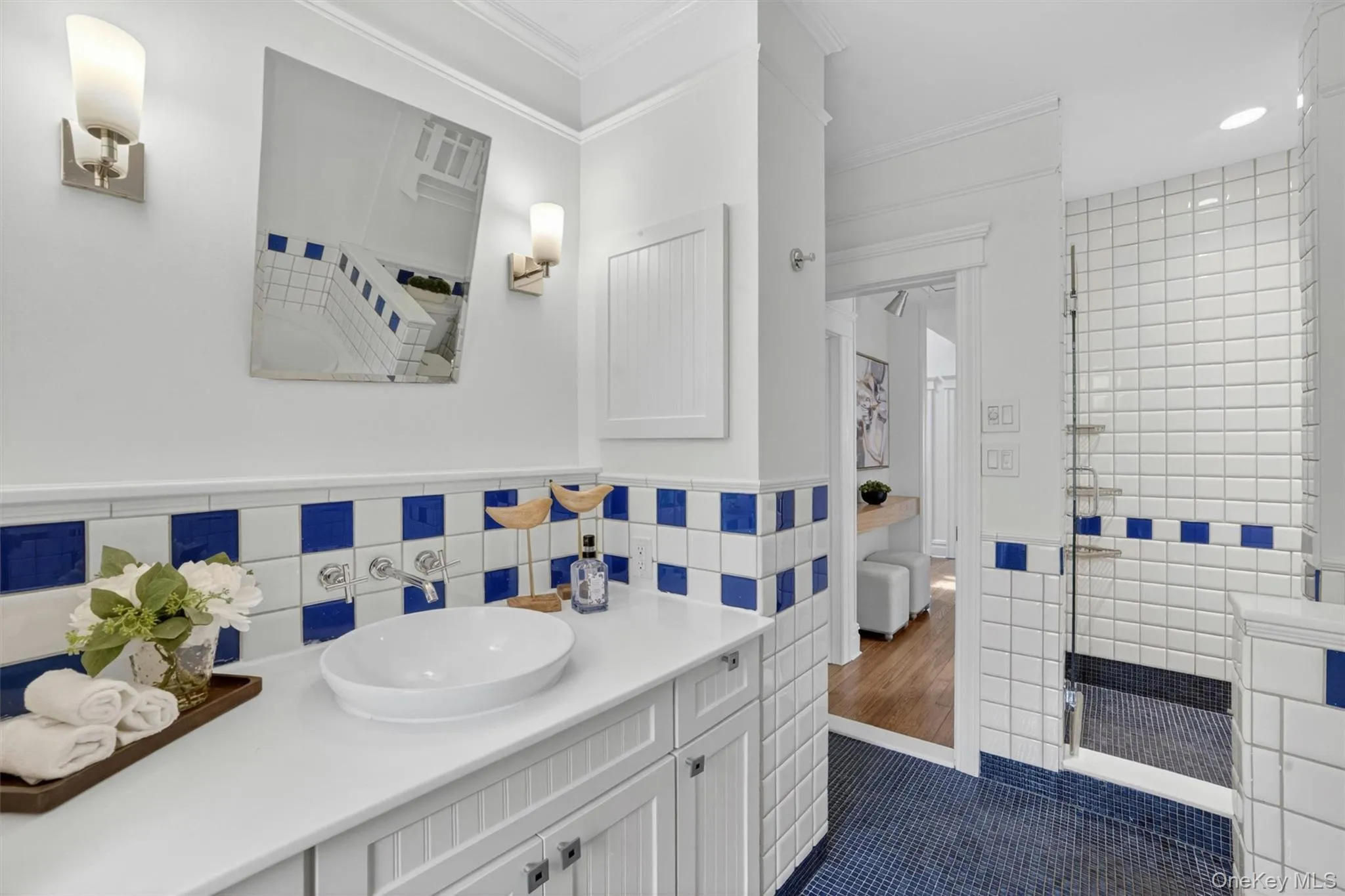 Bathroom featuring a vanity with a surface-mounted oval sink, wall-mounted faucet, and custom cabinetry Bathroom featuring a vanity with a surface-mounted oval sink, wall-mounted faucet, and custom cabinetry