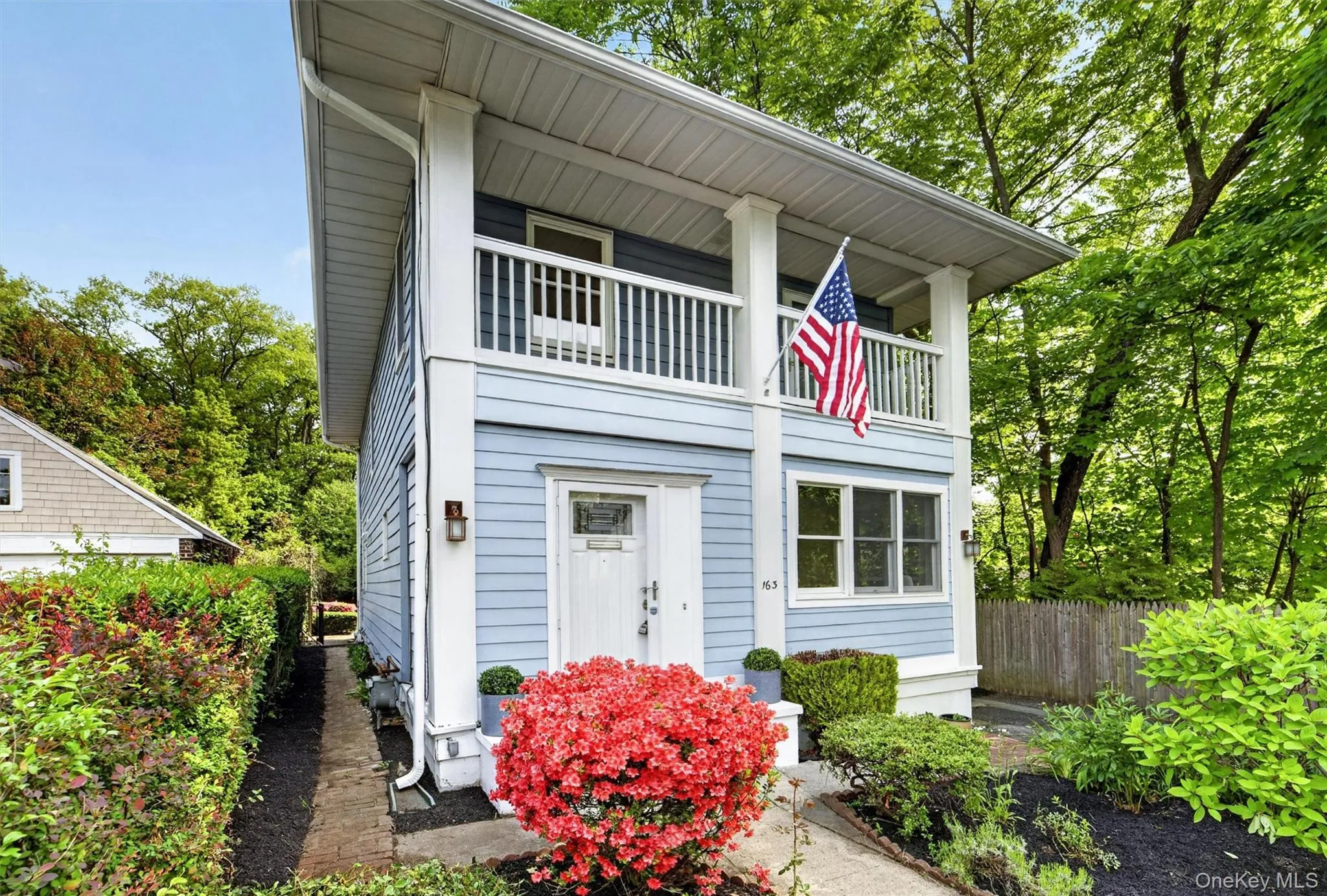 Two-story residence featuring light blue siding and a second-level balcony Two-story residence featuring light blue siding and a second-level balcony