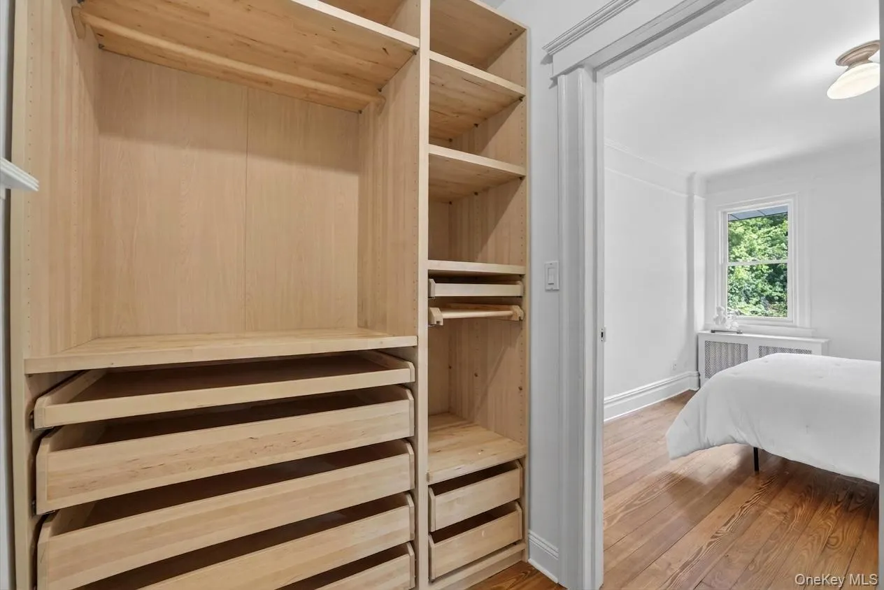 Custom built-in closet system featuring light wood finishes, multiple shelving units, and integrated drawers Custom built-in closet system featuring light wood finishes, multiple shelving units, and integrated drawers