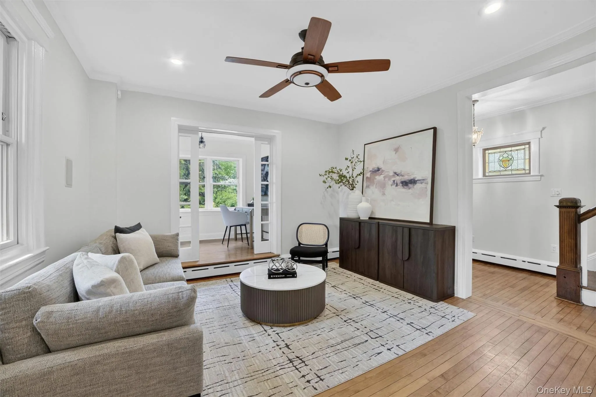 Living area featuring wood-finish flooring, a ceiling fan with integrated lighting, and recessed ceiling lights Living area featuring wood-finish flooring, a ceiling fan with integrated lighting, and recessed ceiling lights