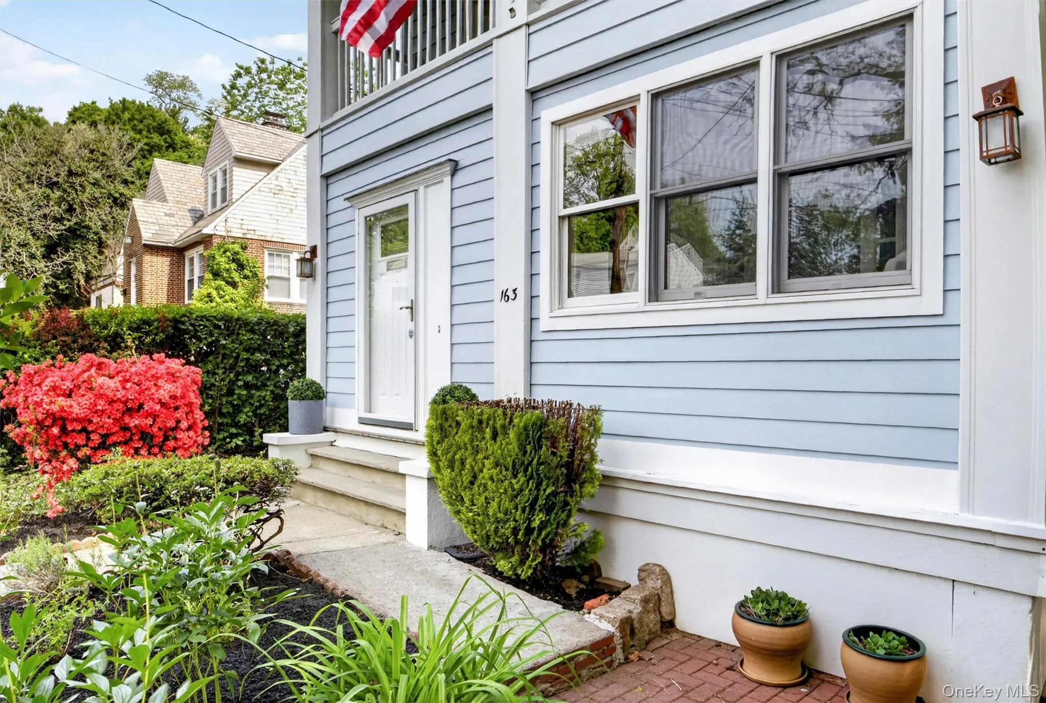 Light blue siding exterior featuring white trim and a white paneled entry door Light blue siding exterior featuring white trim and a white paneled entry door