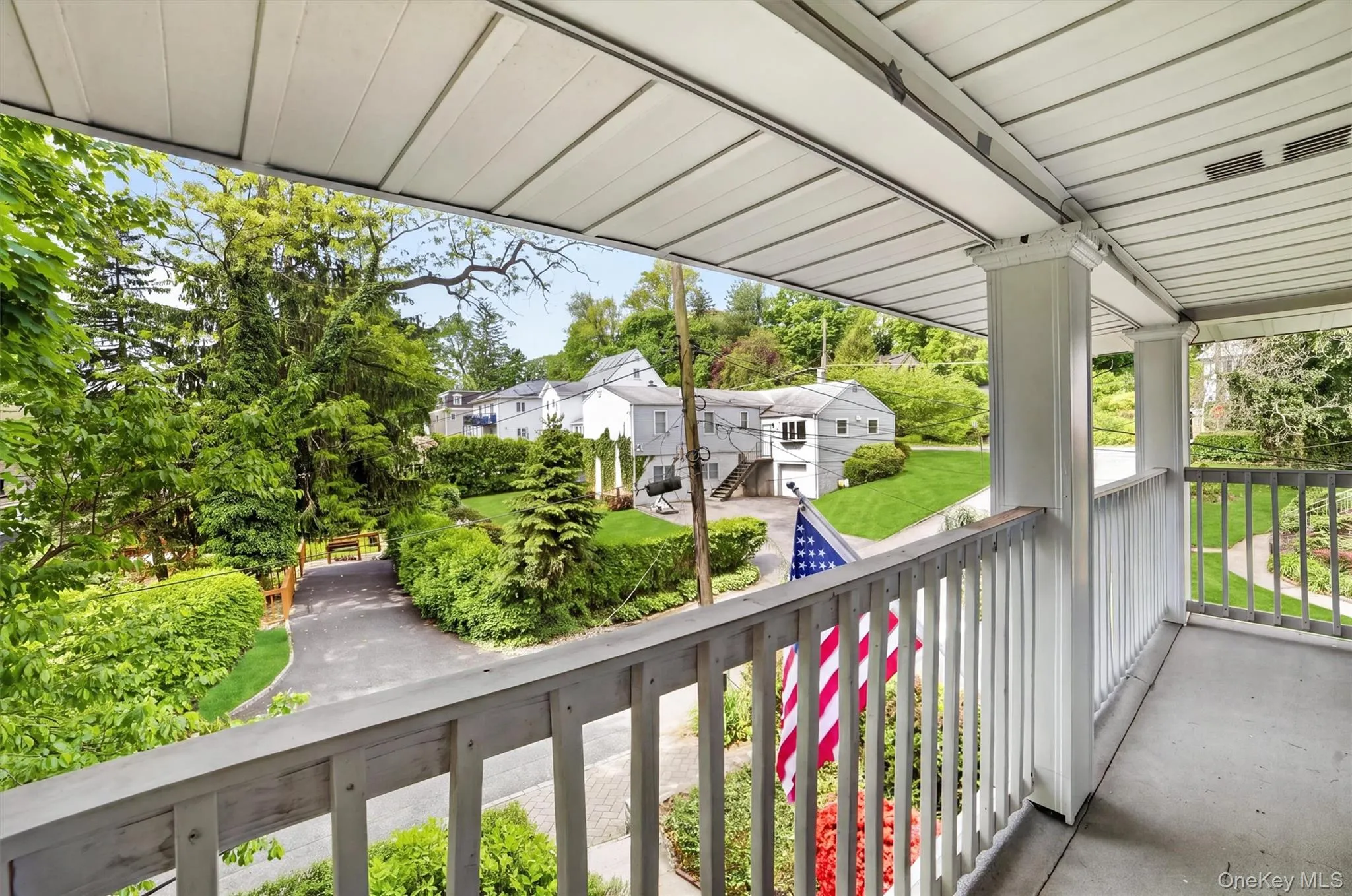 Covered balcony with white wood railing Covered balcony with white wood railing