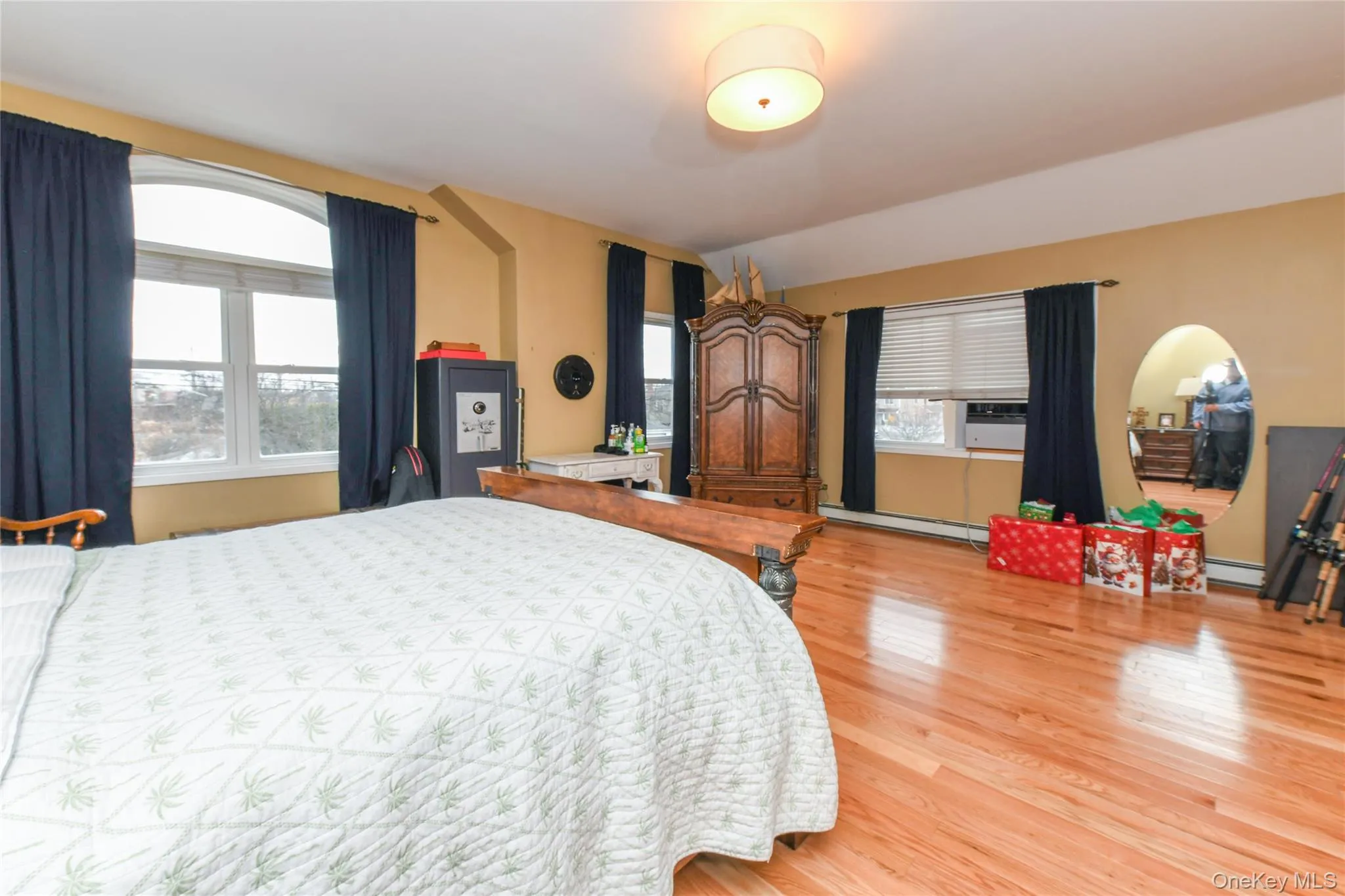 Bedroom with light wood-type flooring and a baseboard heating unit Bedroom with light wood-type flooring and a baseboard heating unit