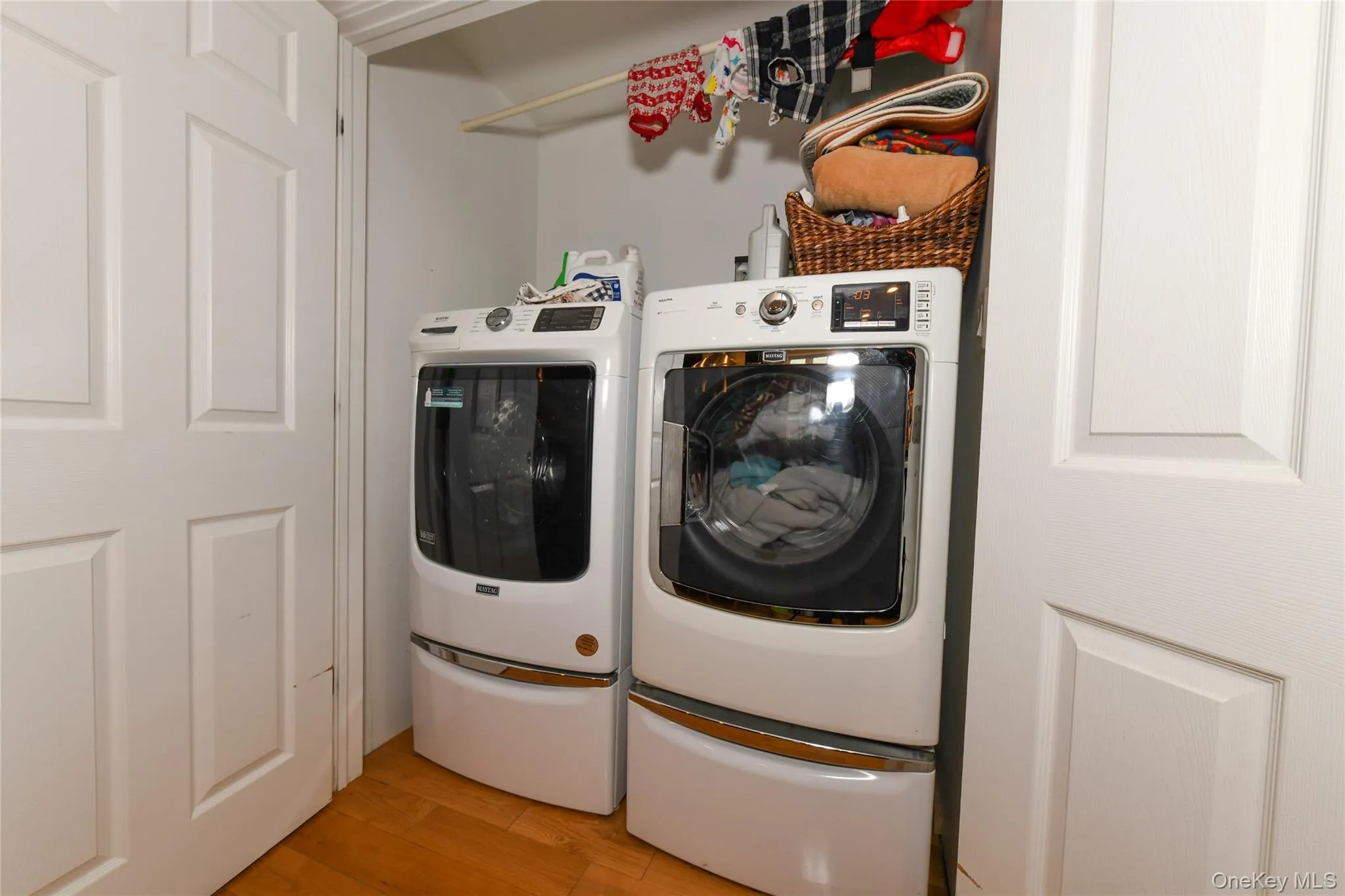 Laundry room with washer and clothes dryer and light wood-type flooring Laundry room with washer and clothes dryer and light wood-type flooring