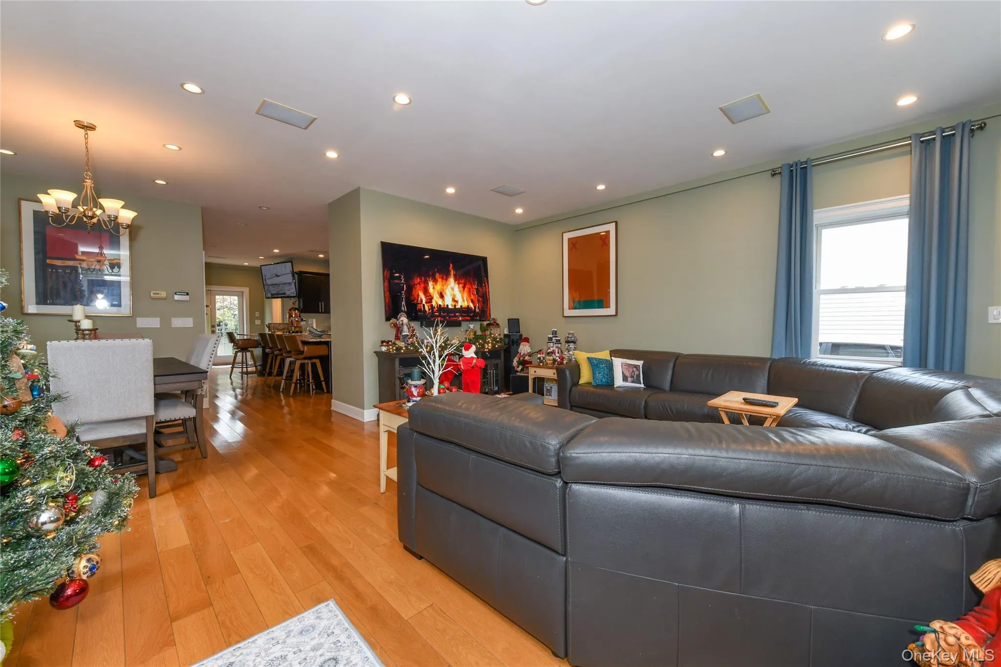 Living room with recessed lighting, light wood-style flooring, and a chandelier Living room with recessed lighting, light wood-style flooring, and a chandelier