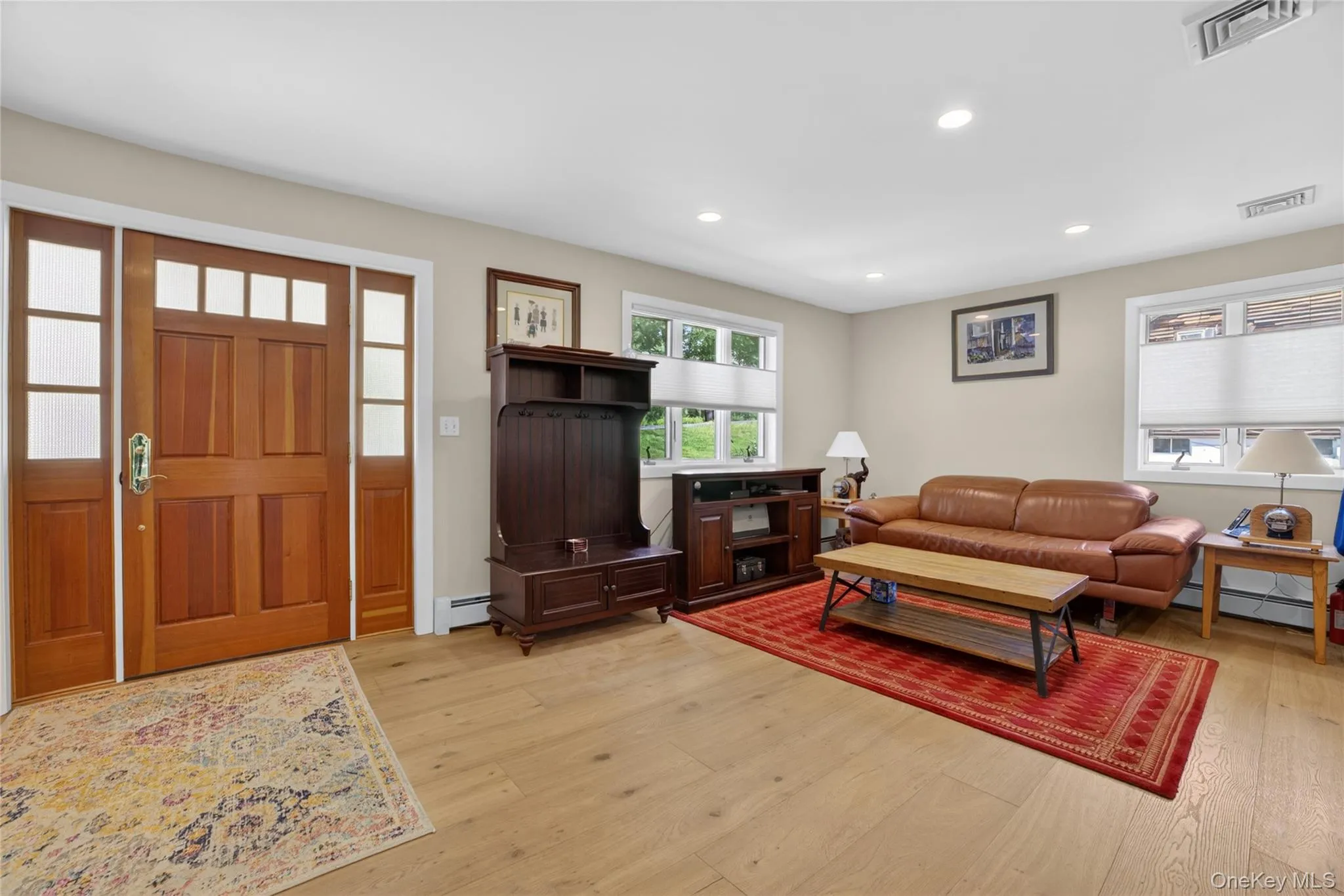The front door entryway into the living area with hardwood floors. The front door entryway into the living area with hardwood floors.