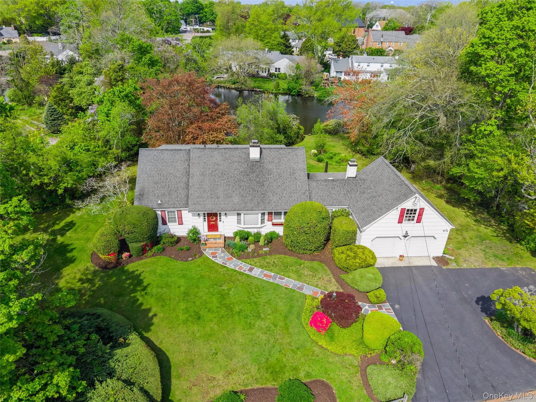 Front of house showing parking and pond. Front of house showing parking and pond.