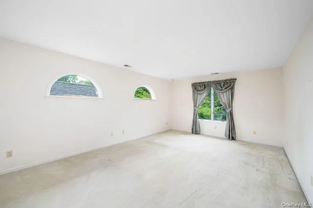 Primary Bedroom, Spacious, featuring multiple windows, including two arched windows and a large rectangular window with drapes Primary Bedroom, Spacious, featuring multiple windows, including two arched windows and a large rectangular window with drapes