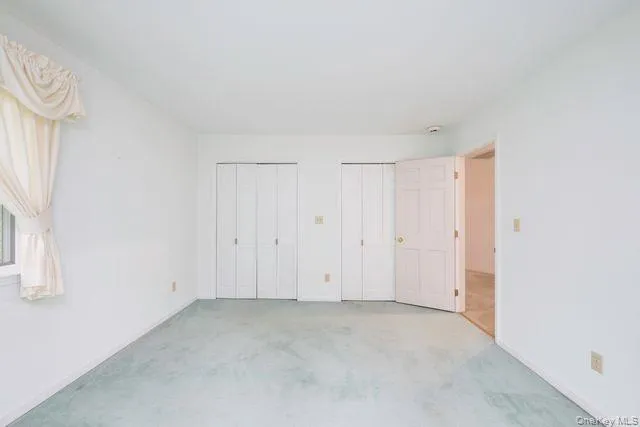 Room featuring light blue wall-to-wall carpeting and white painted walls Room featuring light blue wall-to-wall carpeting and white painted walls