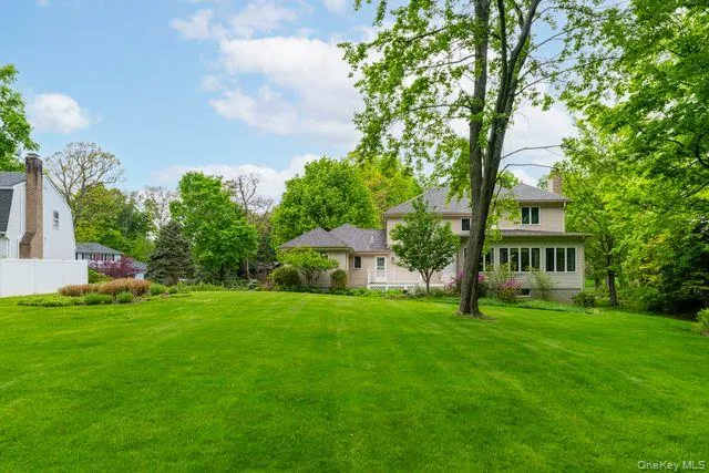 Expansive green lawn with mature trees and perimeter landscaping Expansive green lawn with mature trees and perimeter landscaping