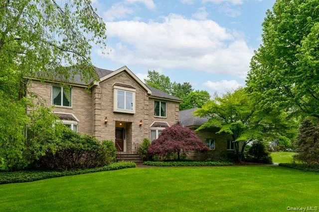 Traditional two-story residence featuring a brick facade with stone accents Traditional two-story residence featuring a brick facade with stone accents
