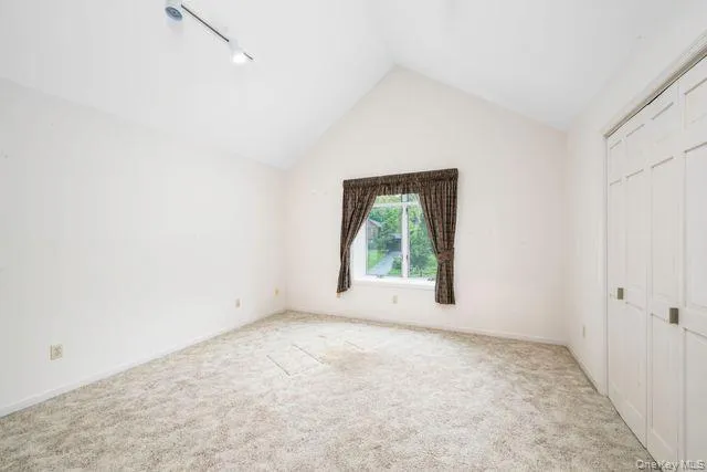 Bedroom Room (Office) featuring a vaulted ceiling, track lighting, and soft carpet flooring Bedroom Room (Office) featuring a vaulted ceiling, track lighting, and soft carpet flooring