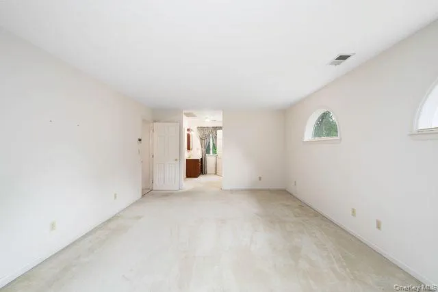 Primary Bedroom, Spacious, with light-colored carpeting, white walls, and a white ceiling Primary Bedroom, Spacious, with light-colored carpeting, white walls, and a white ceiling