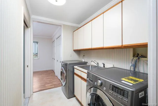 First floor Laundry room featuring extensive built-in cabinetry, and a utility sink First floor Laundry room featuring extensive built-in cabinetry, and a utility sink