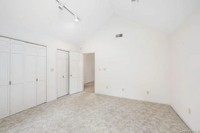 Bedroom Room (Office), featuring a vaulted ceiling with track lighting, dual bi-fold closet doors Bedroom Room (Office), featuring a vaulted ceiling with track lighting, dual bi-fold closet doors