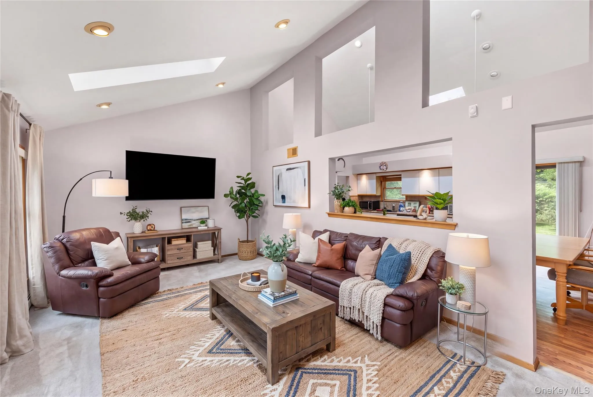 Vaulted ceiling with skylights, recessed lighting, and a pass-through kitchen opening*Virtually staged Vaulted ceiling with skylights, recessed lighting, and a pass-through kitchen opening*Virtually staged