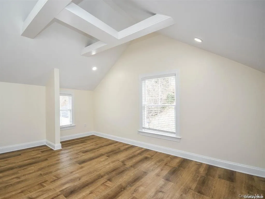 Bonus room featuring recessed lighting, lofted ceiling, baseboards, and wood finished floors Bonus room featuring recessed lighting, lofted ceiling, baseboards, and wood finished floors