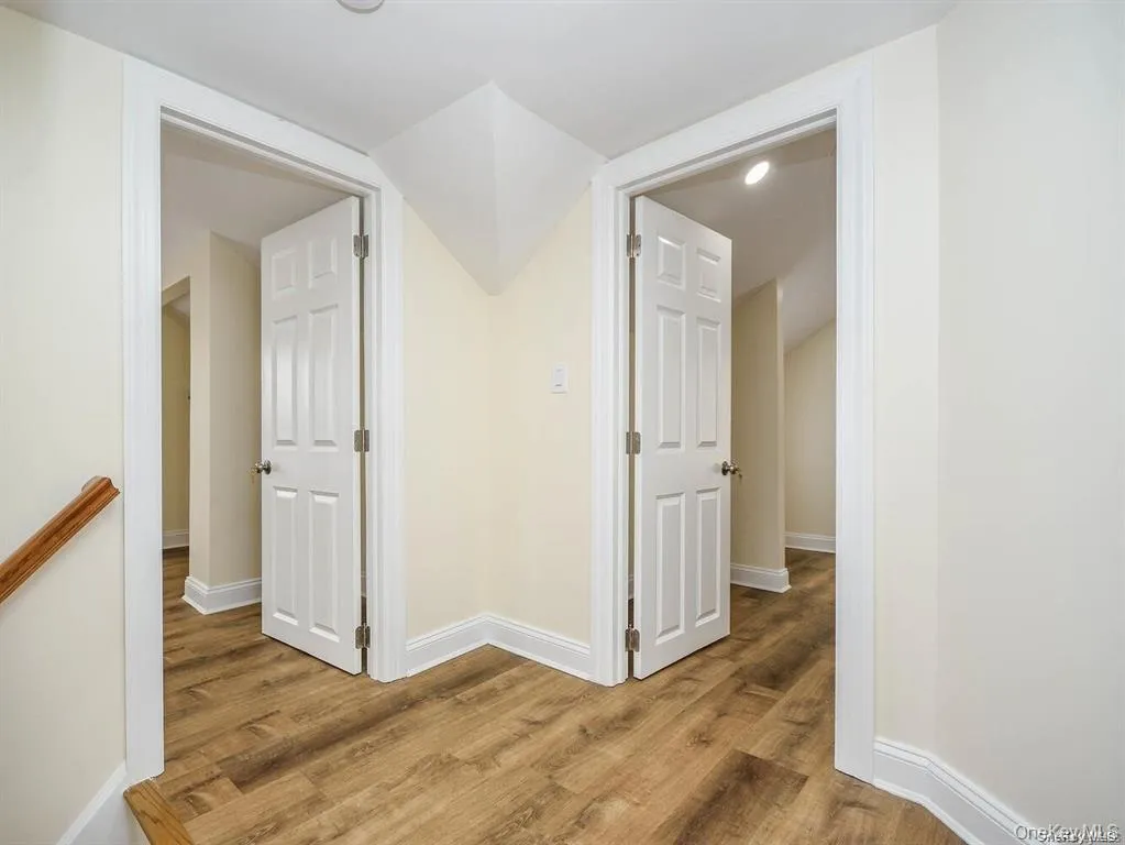 Hallway featuring baseboards and light wood finished floors Hallway featuring baseboards and light wood finished floors