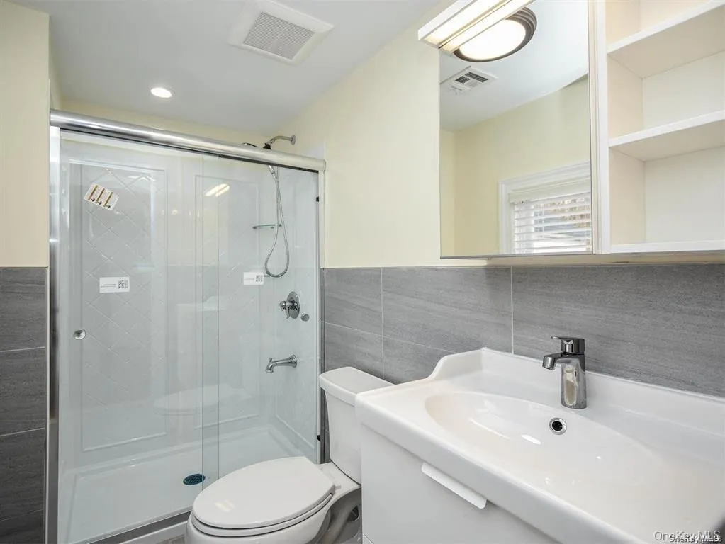 Bathroom with visible vents and a stall shower Bathroom with visible vents and a stall shower