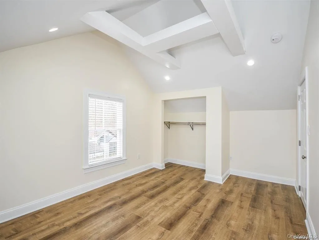 Additional living space featuring recessed lighting, lofted ceiling with beams, baseboards, and wood finished floors Additional living space featuring recessed lighting, lofted ceiling with beams, baseboards, and wood finished floors