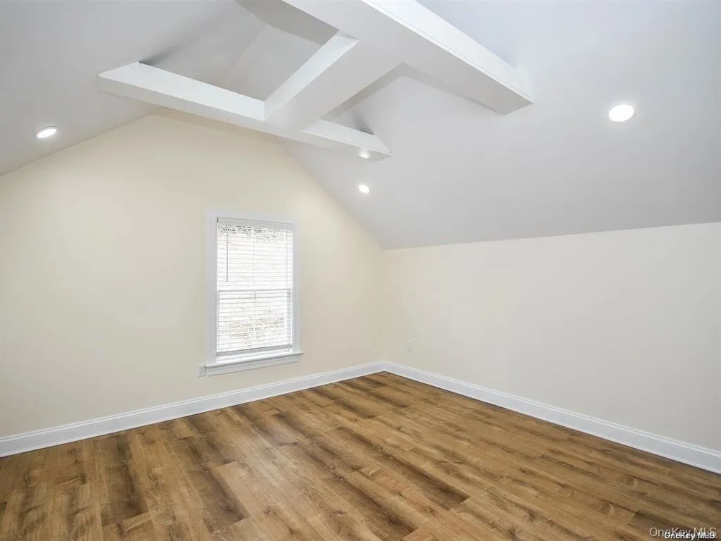 Bonus room with baseboards, lofted ceiling, and wood finished floors Bonus room with baseboards, lofted ceiling, and wood finished floors
