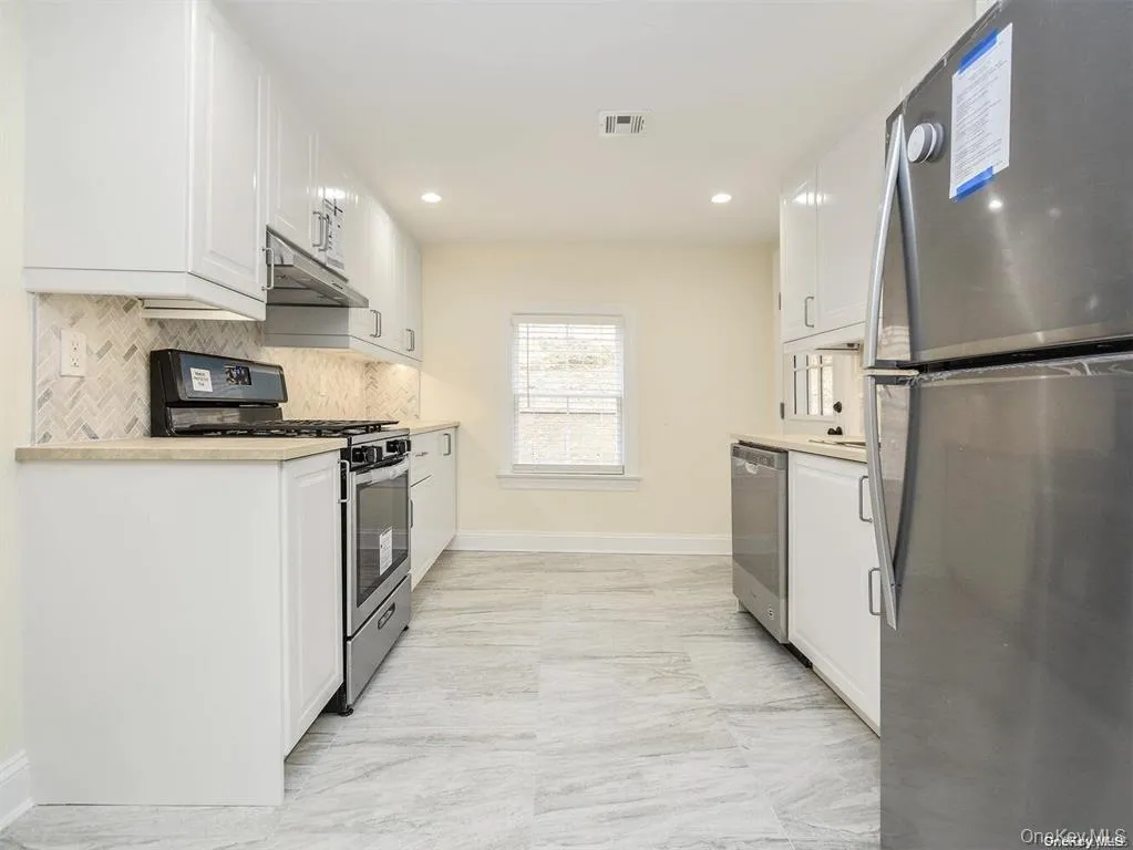 Kitchen with visible vents, white cabinets, stainless steel appliances, and light countertops Kitchen with visible vents, white cabinets, stainless steel appliances, and light countertops
