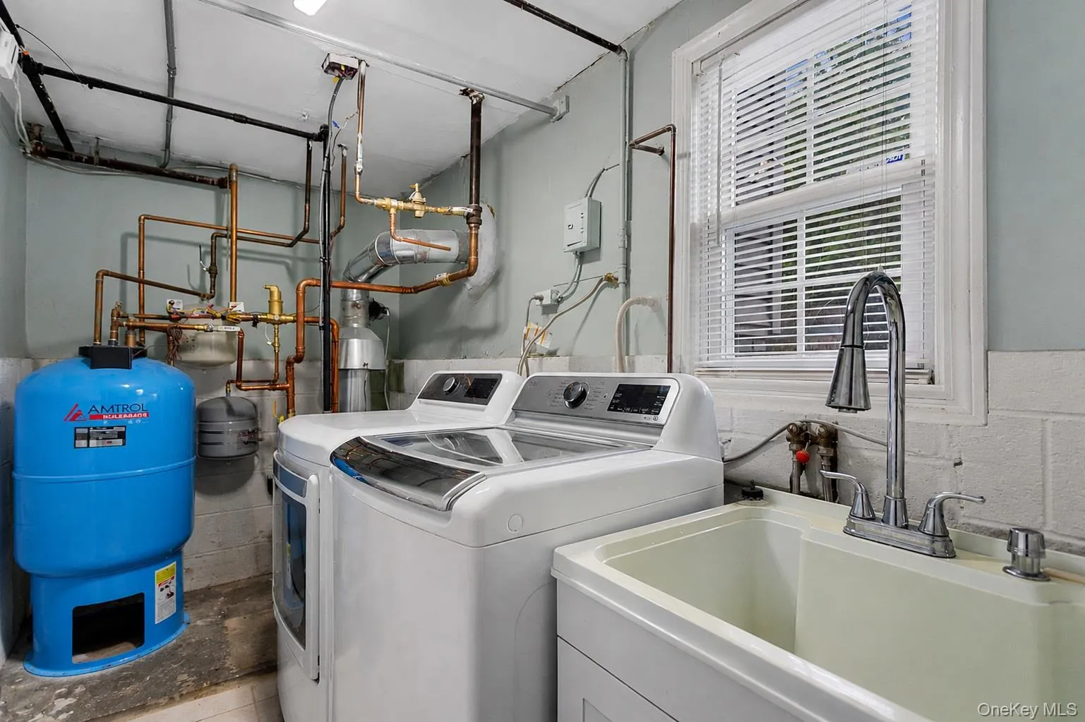 Laundry room with utility sink and washer/dryer. Laundry room with utility sink and washer/dryer.