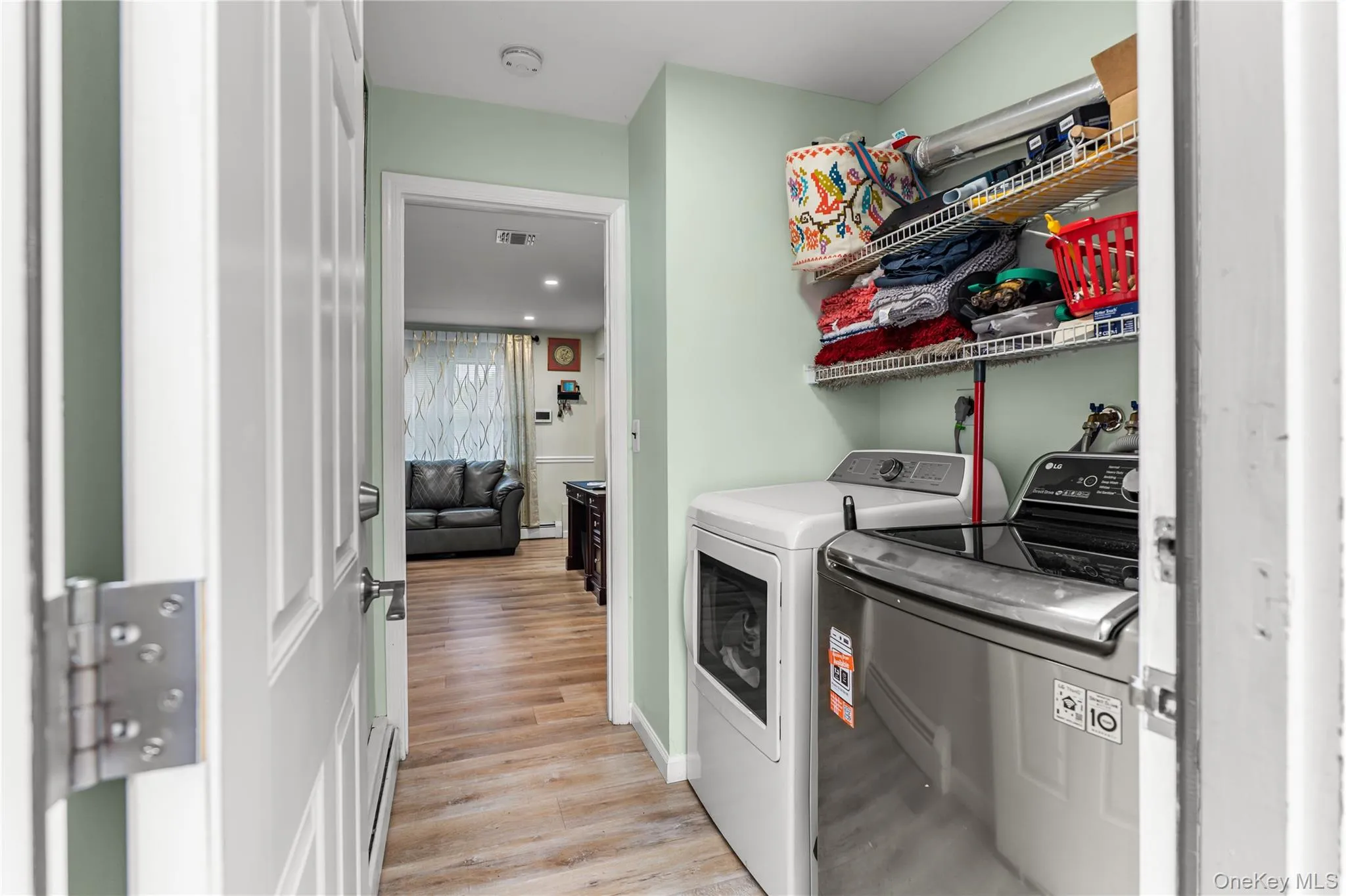 Dedicated laundry area featuring a white dryer and a stainless steel washing machine Dedicated laundry area featuring a white dryer and a stainless steel washing machine