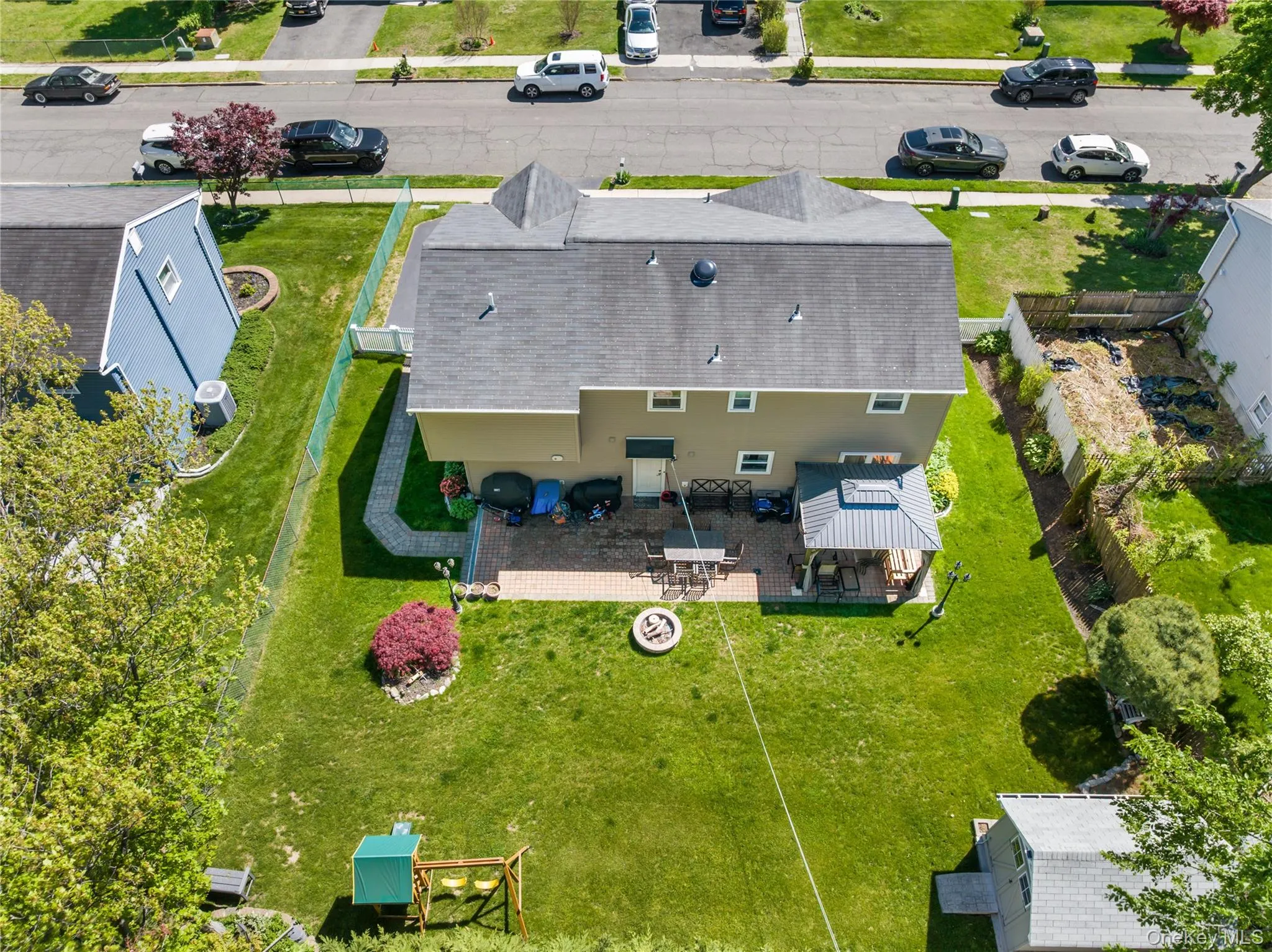 Expansive rear yard featuring a paved patio area, covered gazebo, and a fire pit Expansive rear yard featuring a paved patio area, covered gazebo, and a fire pit