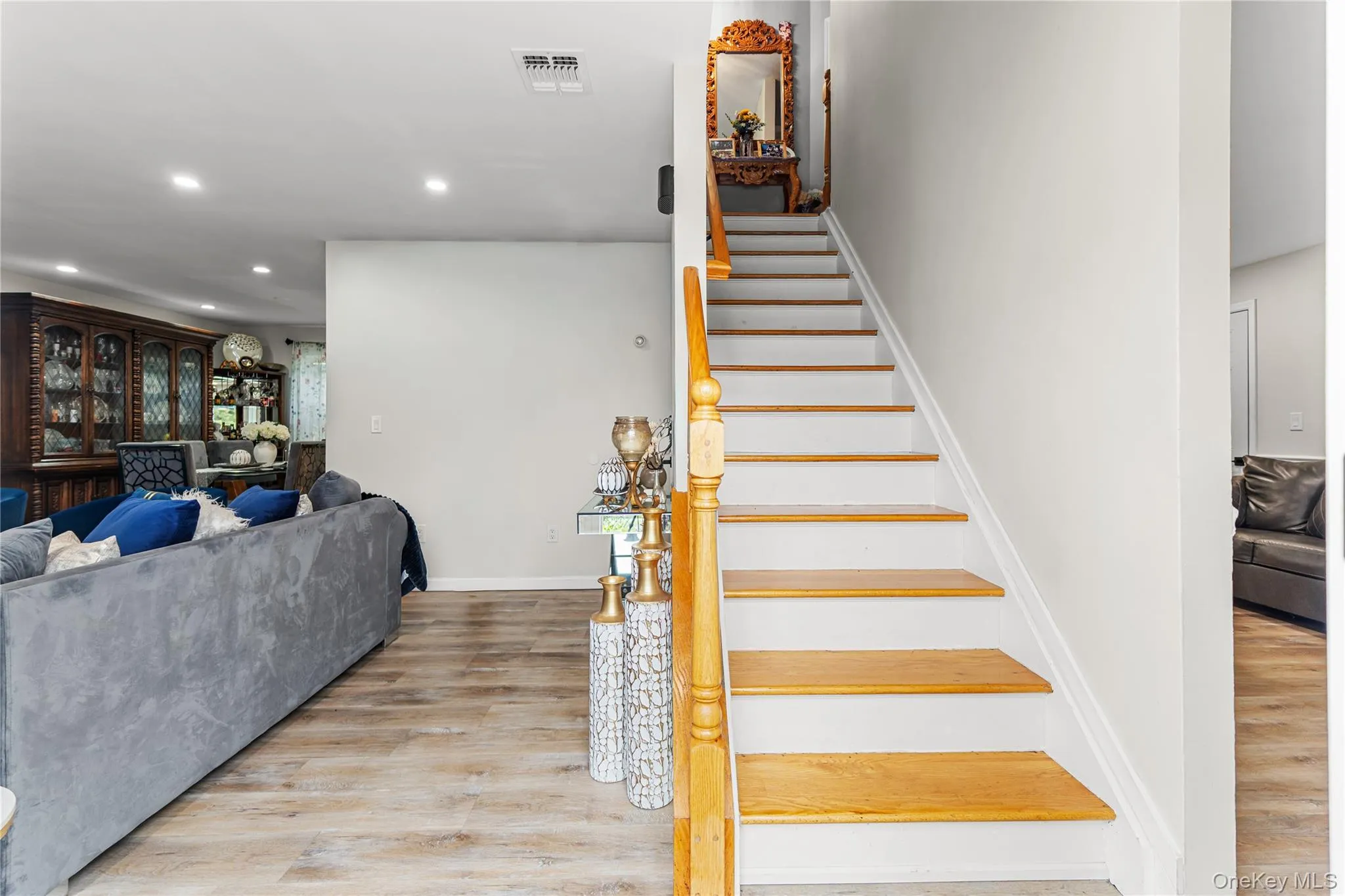 Staircase featuring wood treads and white risers with a wood handrail Staircase featuring wood treads and white risers with a wood handrail