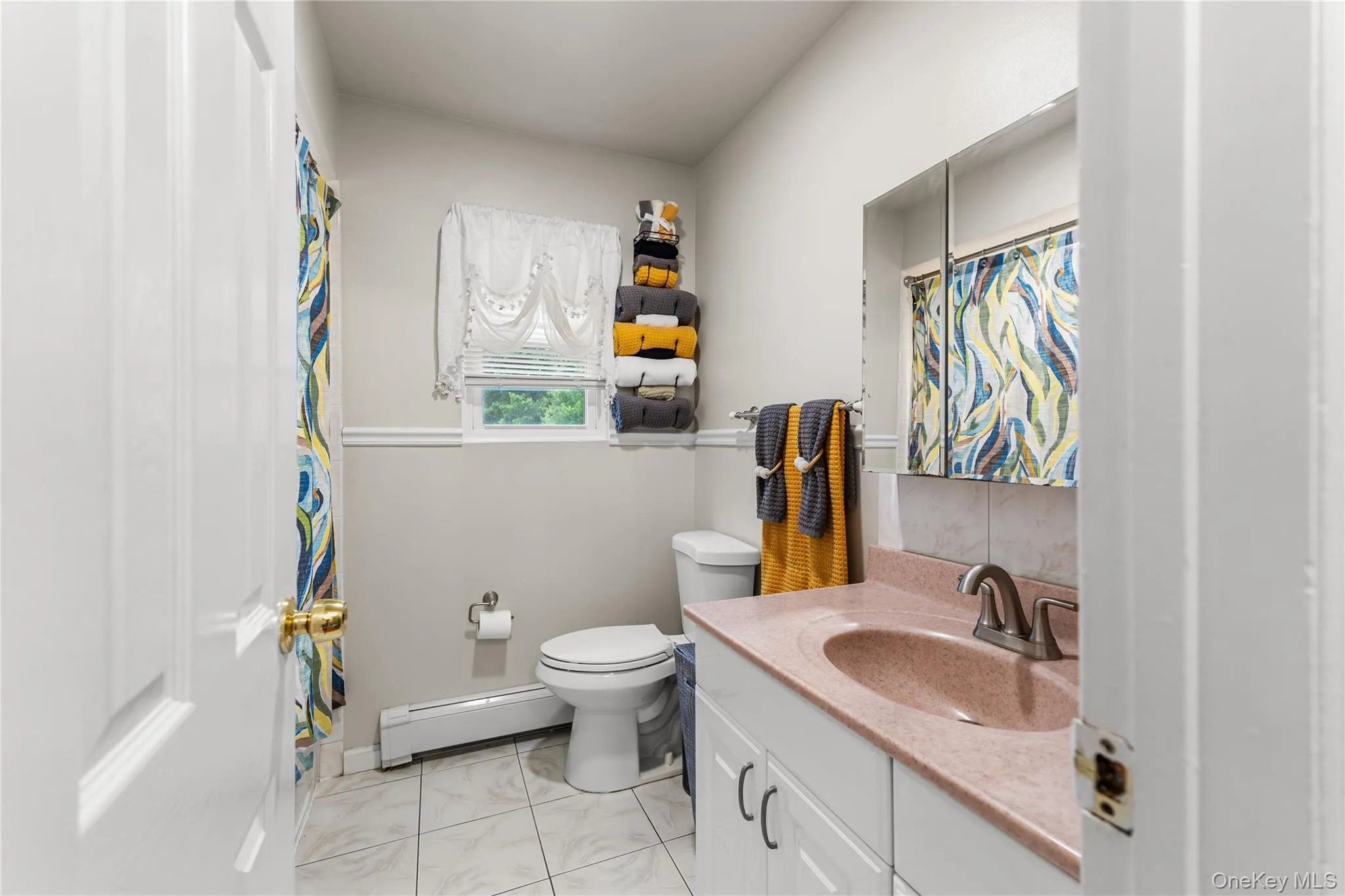 Bathroom featuring a vanity with a reddish countertop, built-in medicine cabinet, white tile flooring, and a window Bathroom featuring a vanity with a reddish countertop, built-in medicine cabinet, white tile flooring, and a window